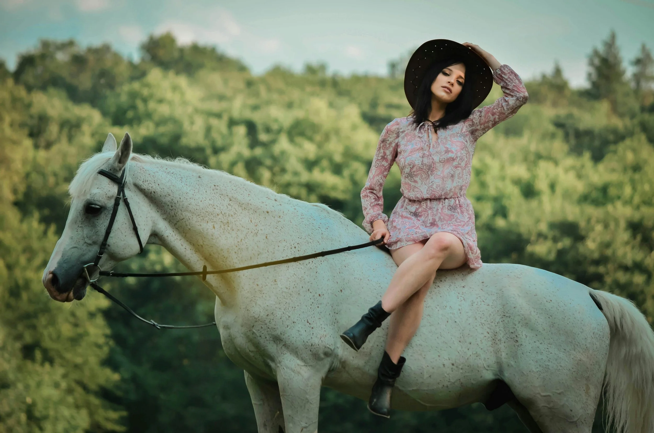 girl sat on her horse barback wearing a hat