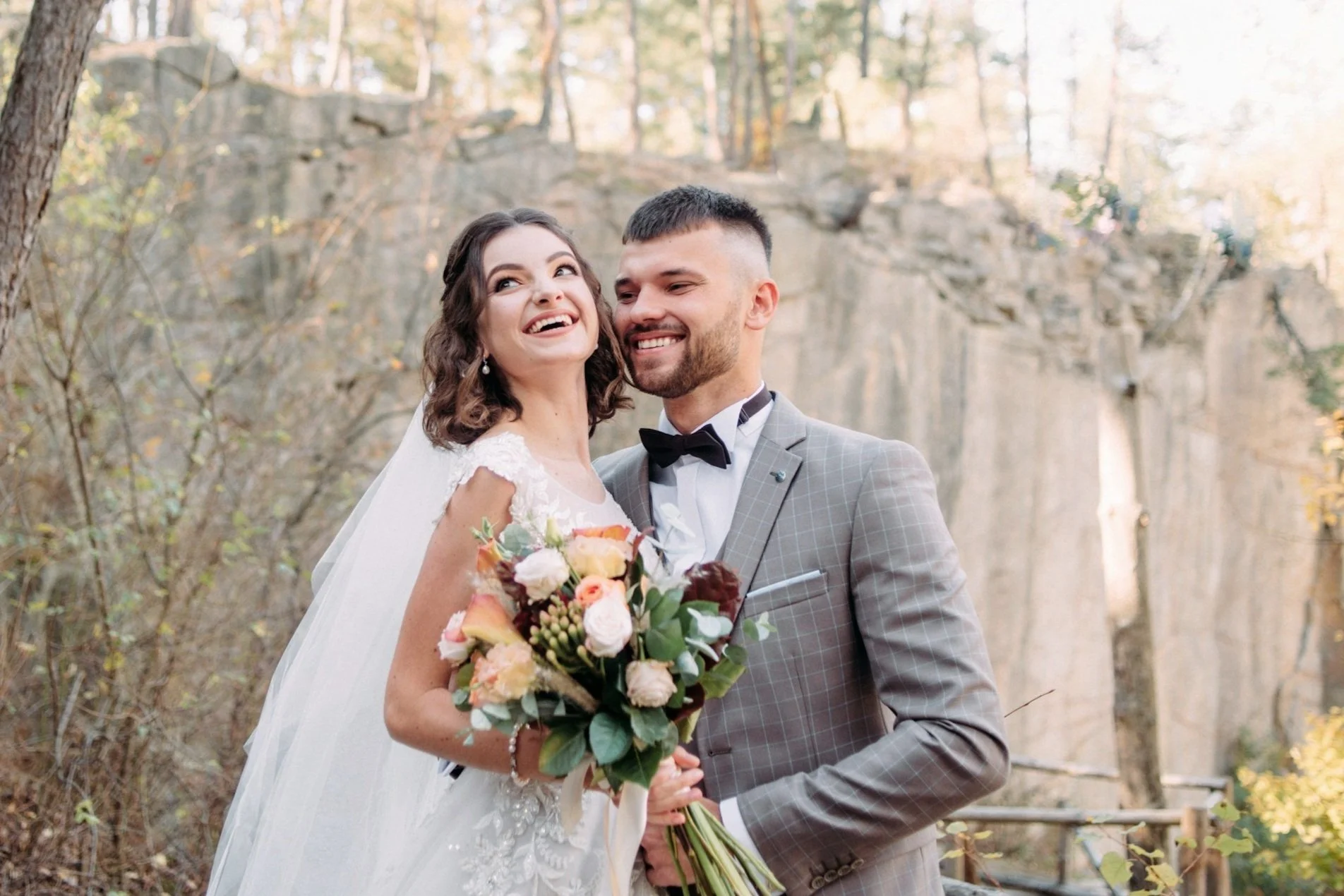 bride and groom together looking happy whilst bride holding her wedding flowers