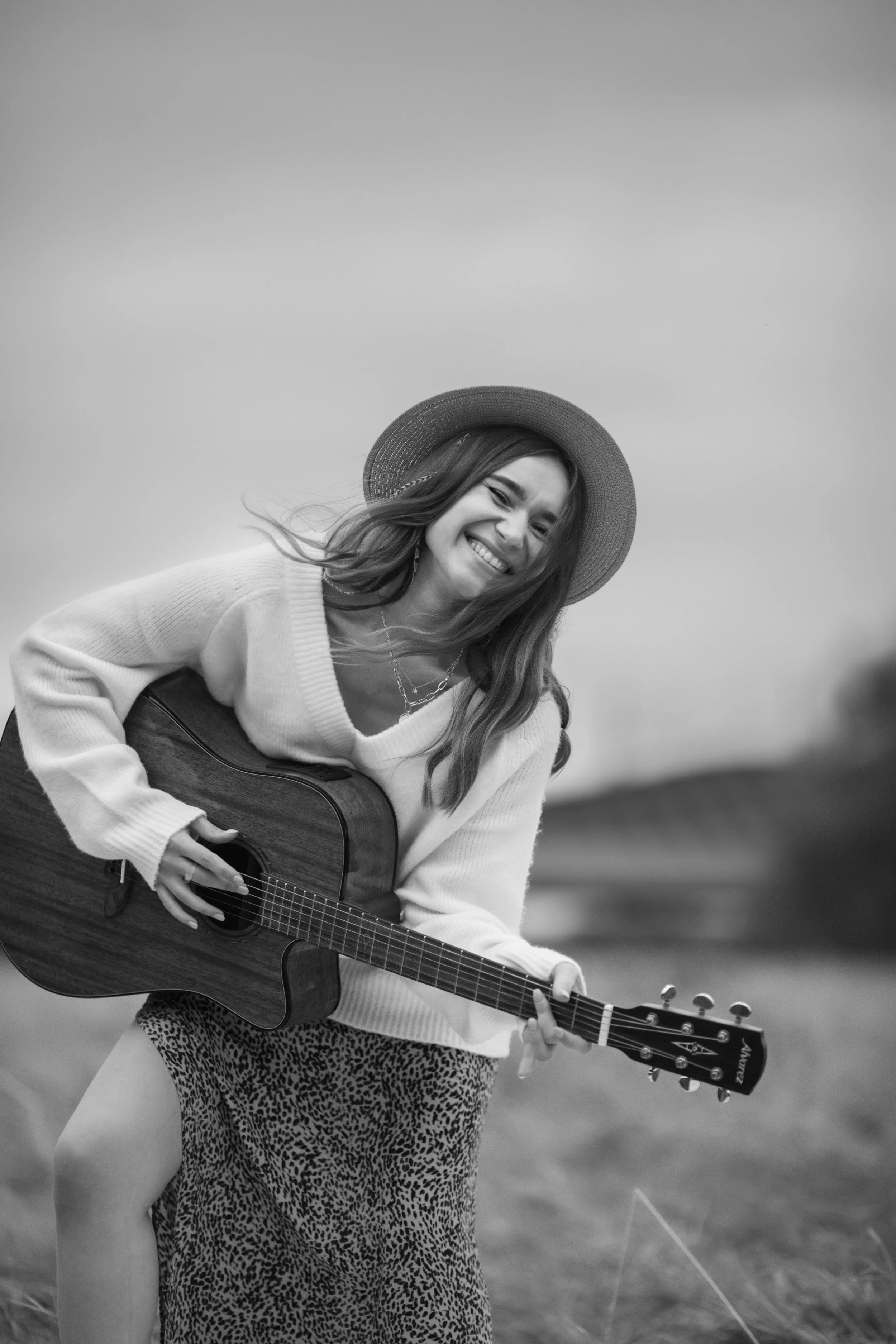 country singer in open fields with guitar black and white image