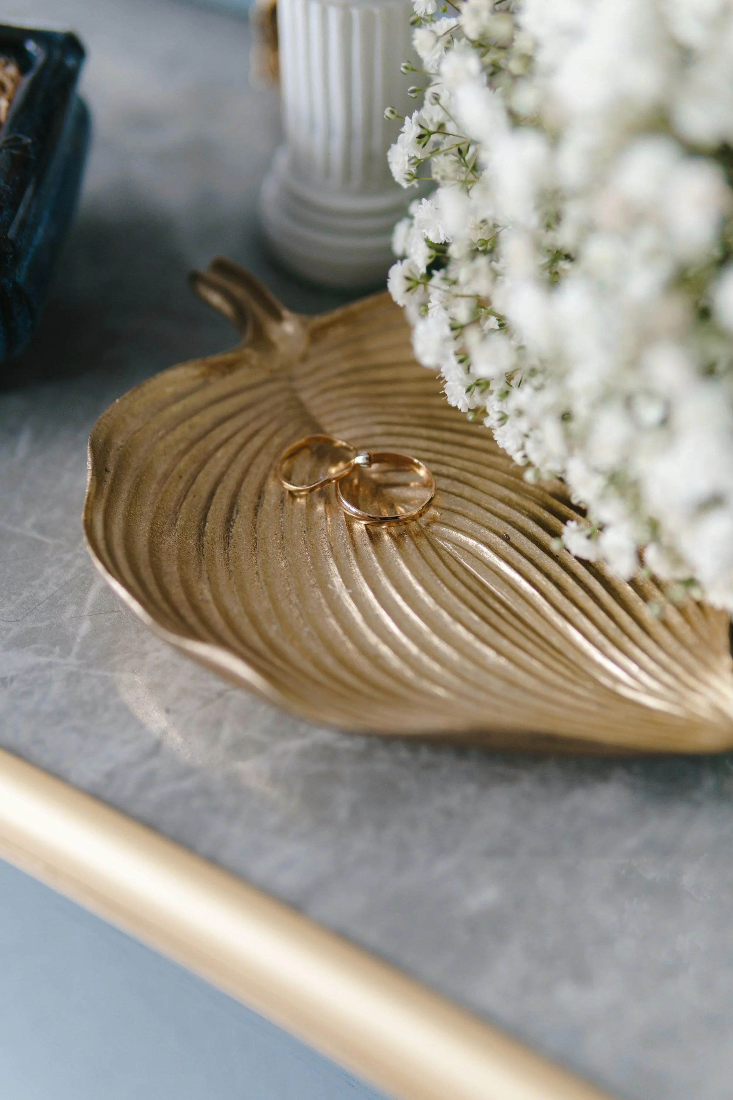 wedding rings in gold tray with white flowers