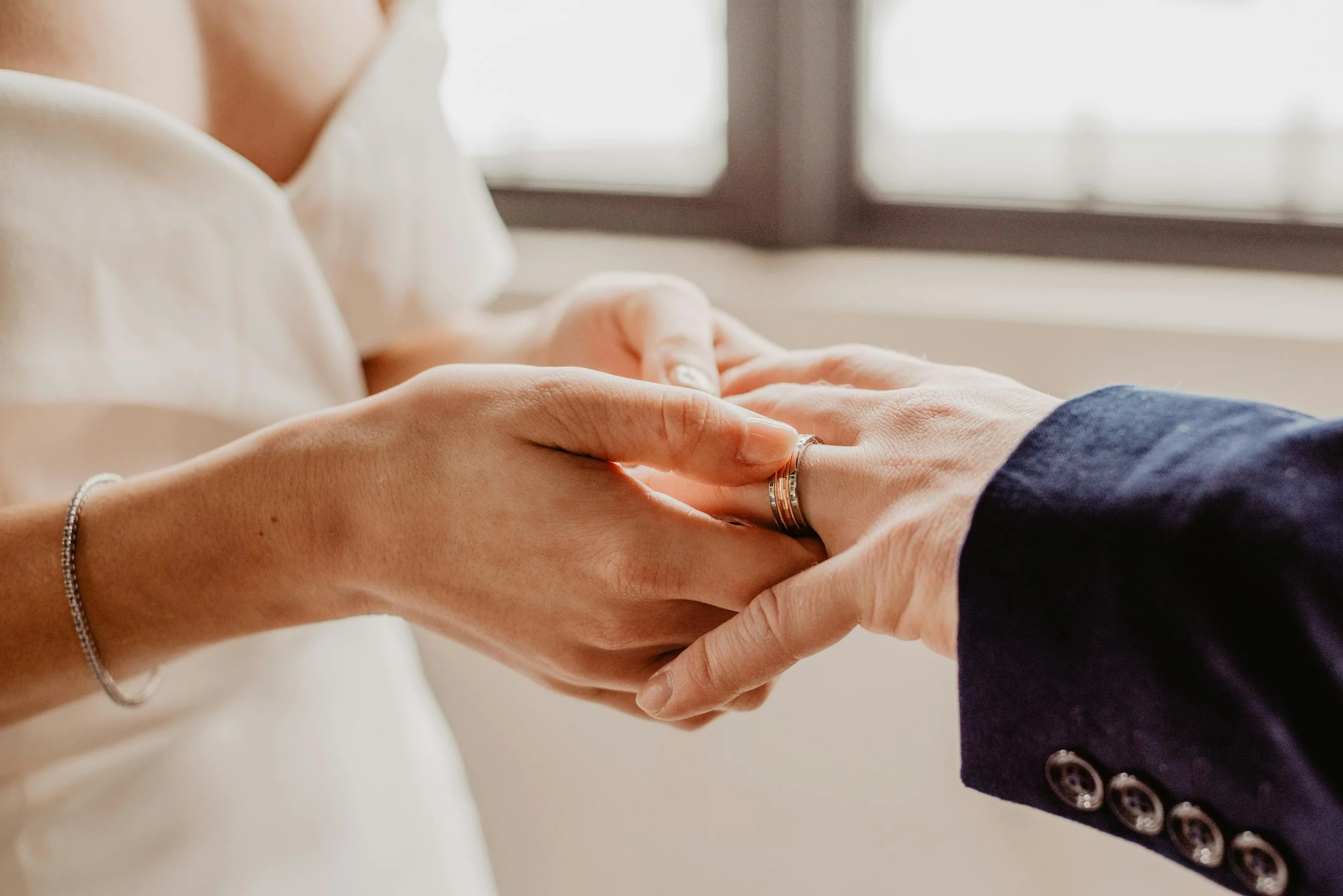 bride and groom wedding rings holding hands