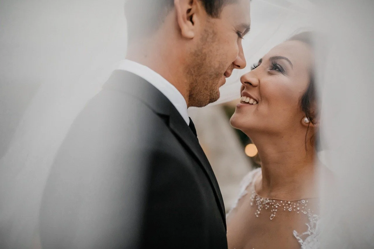 bride and groom headshot under brides veil