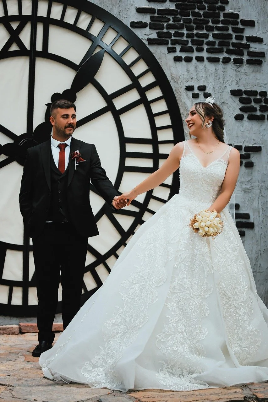 groom and bride together holding hands with wall clock behind them