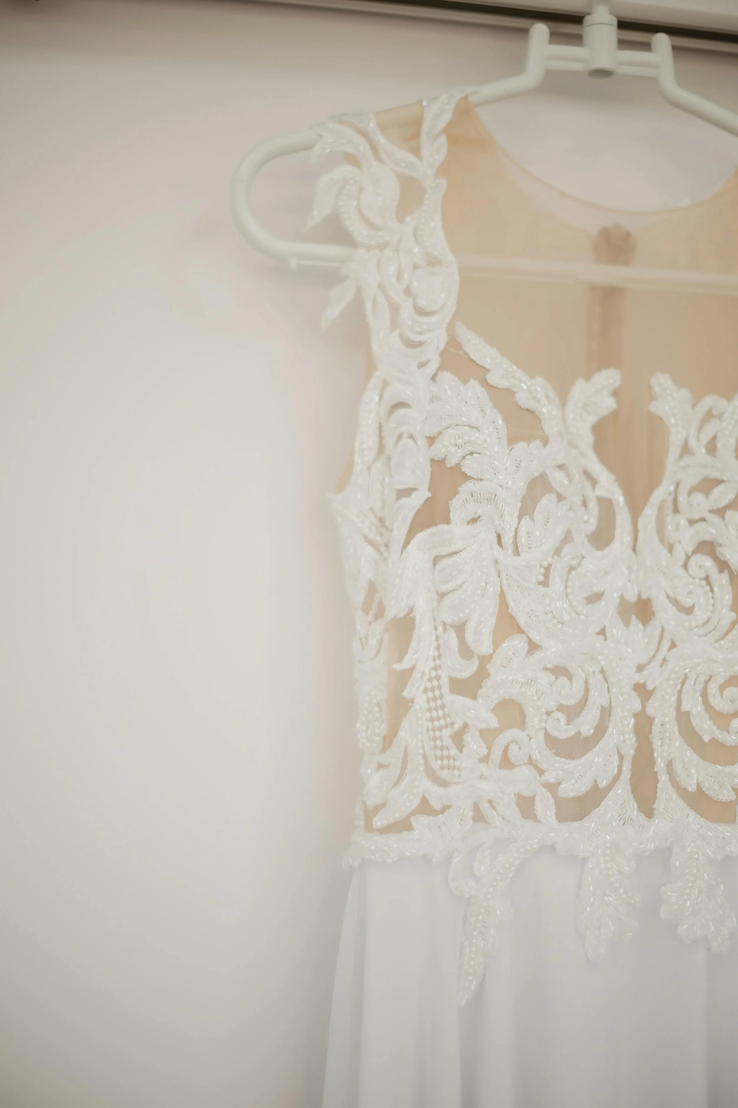 brides white lace wedding dress hung up
