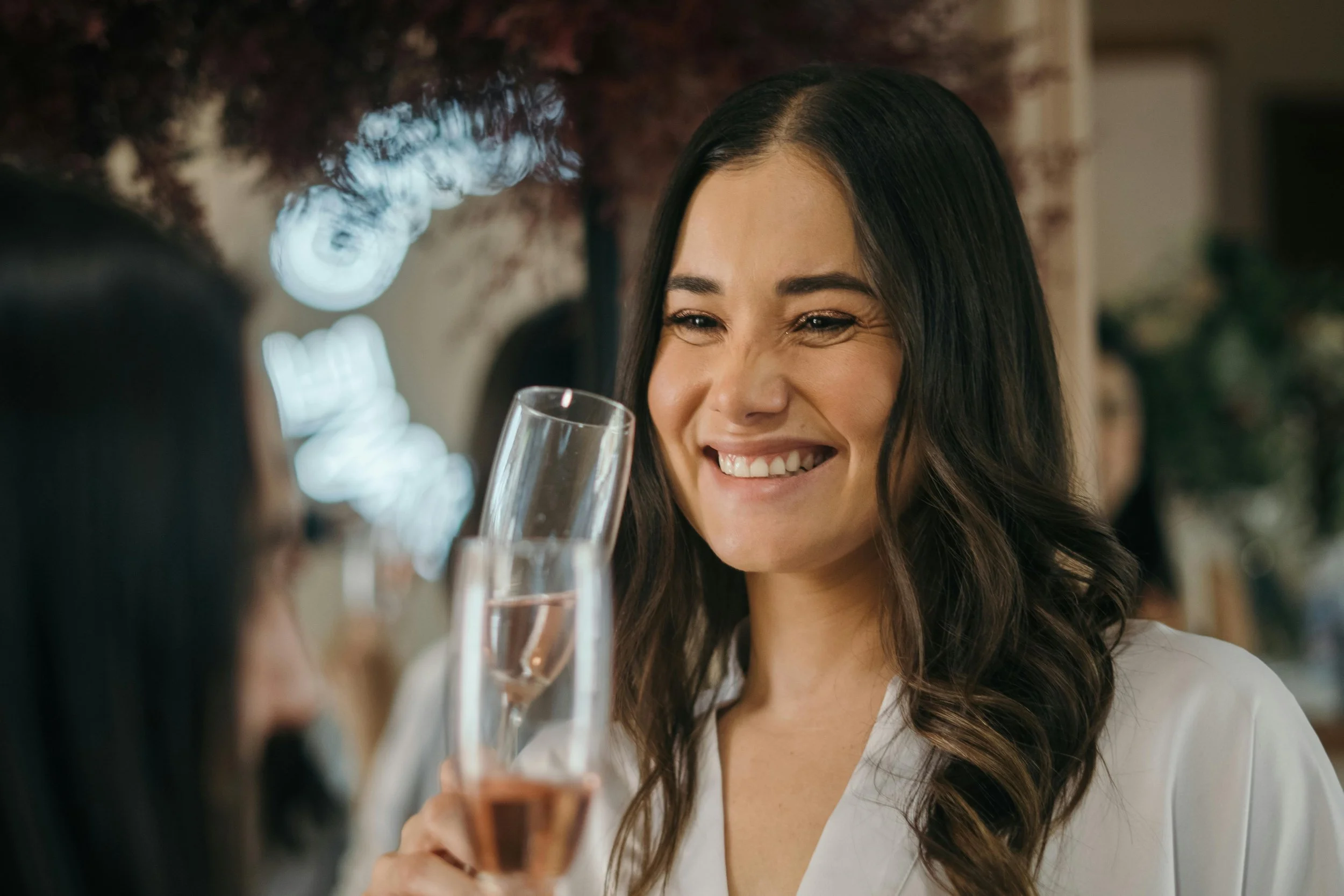 bride getting ready on the morning of her wedding day holding a glass of bubbles