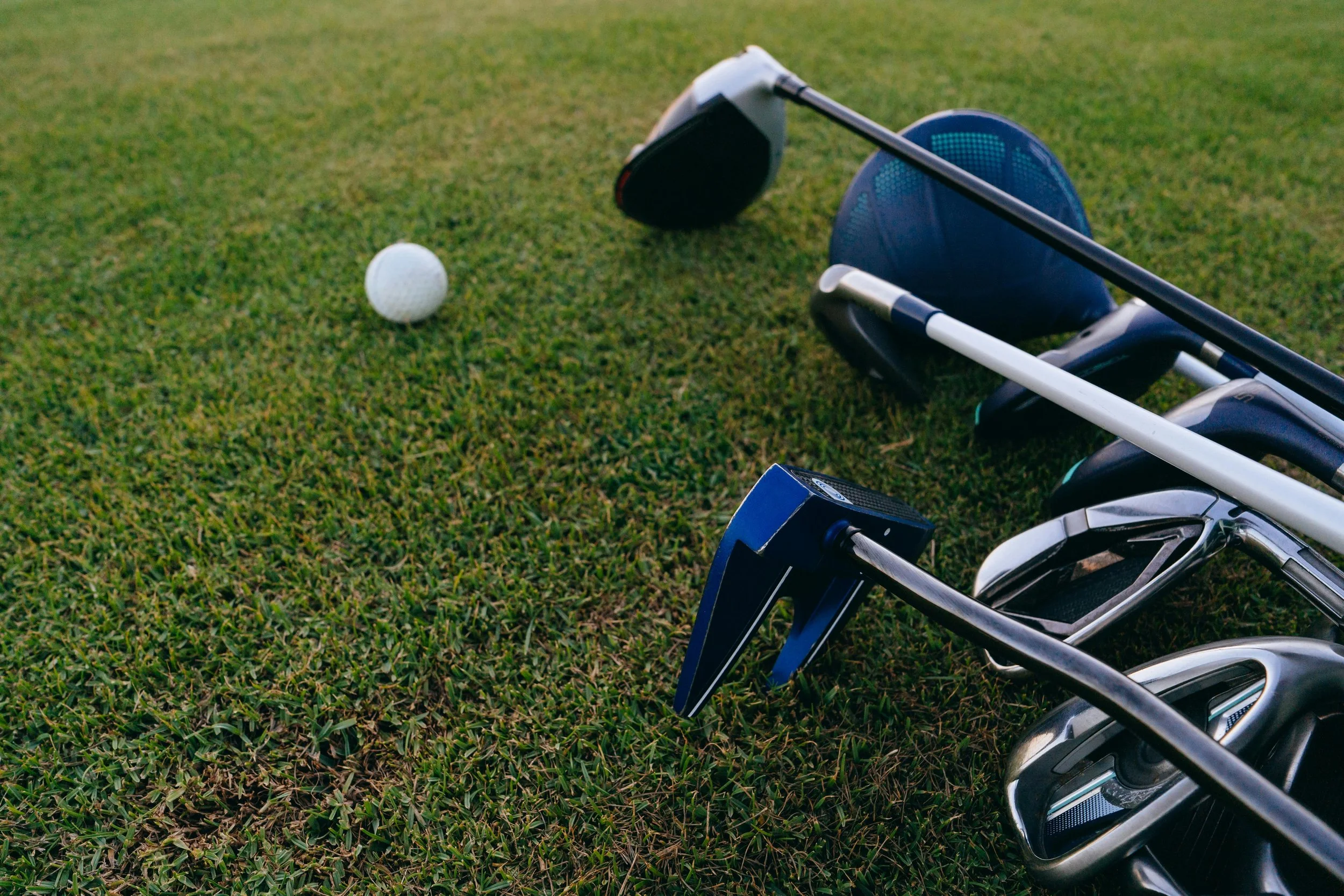 golf clubs and golf ball on green