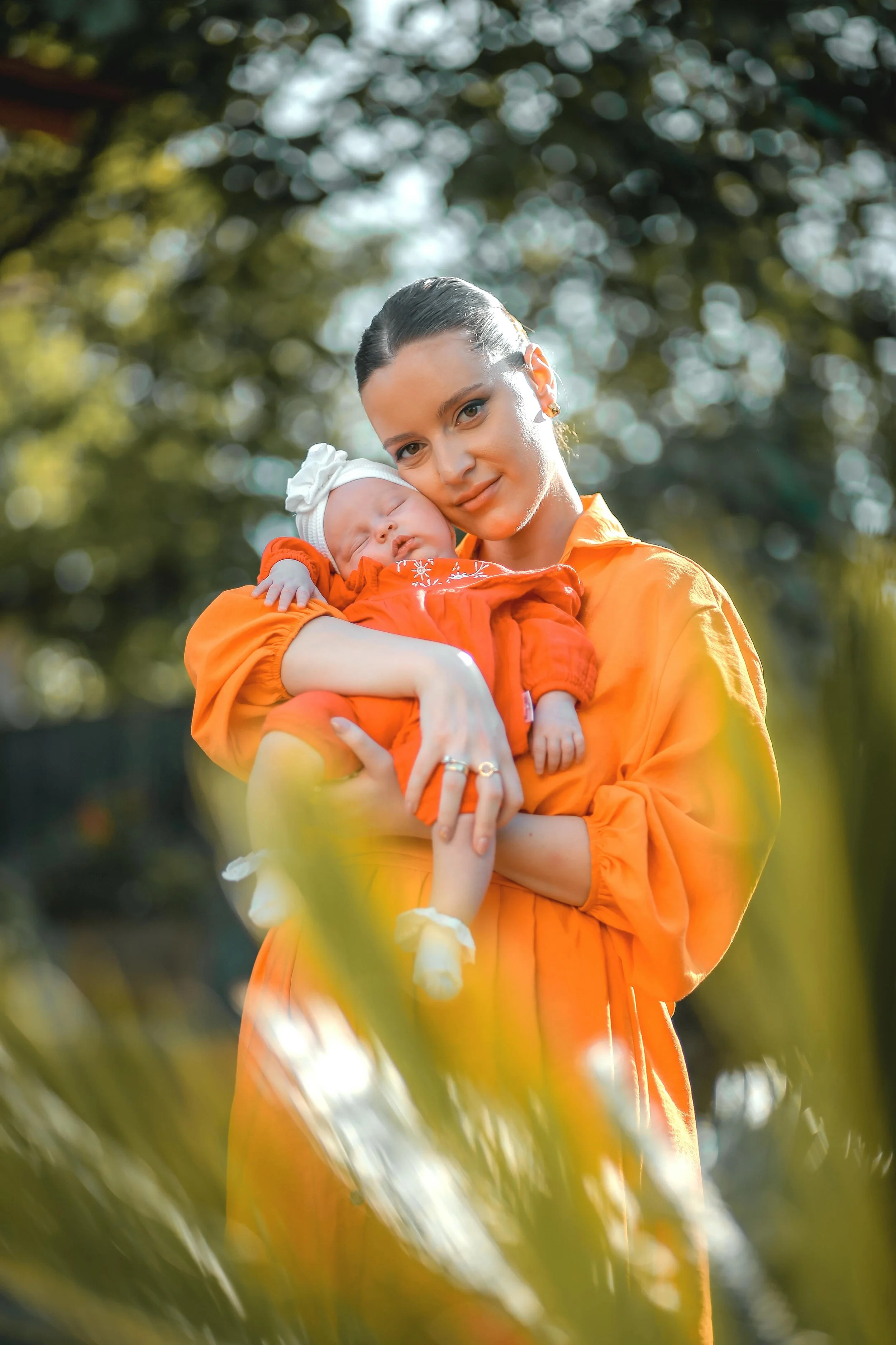 new mother holding her baby in her arms and resting her cheek against her baby's