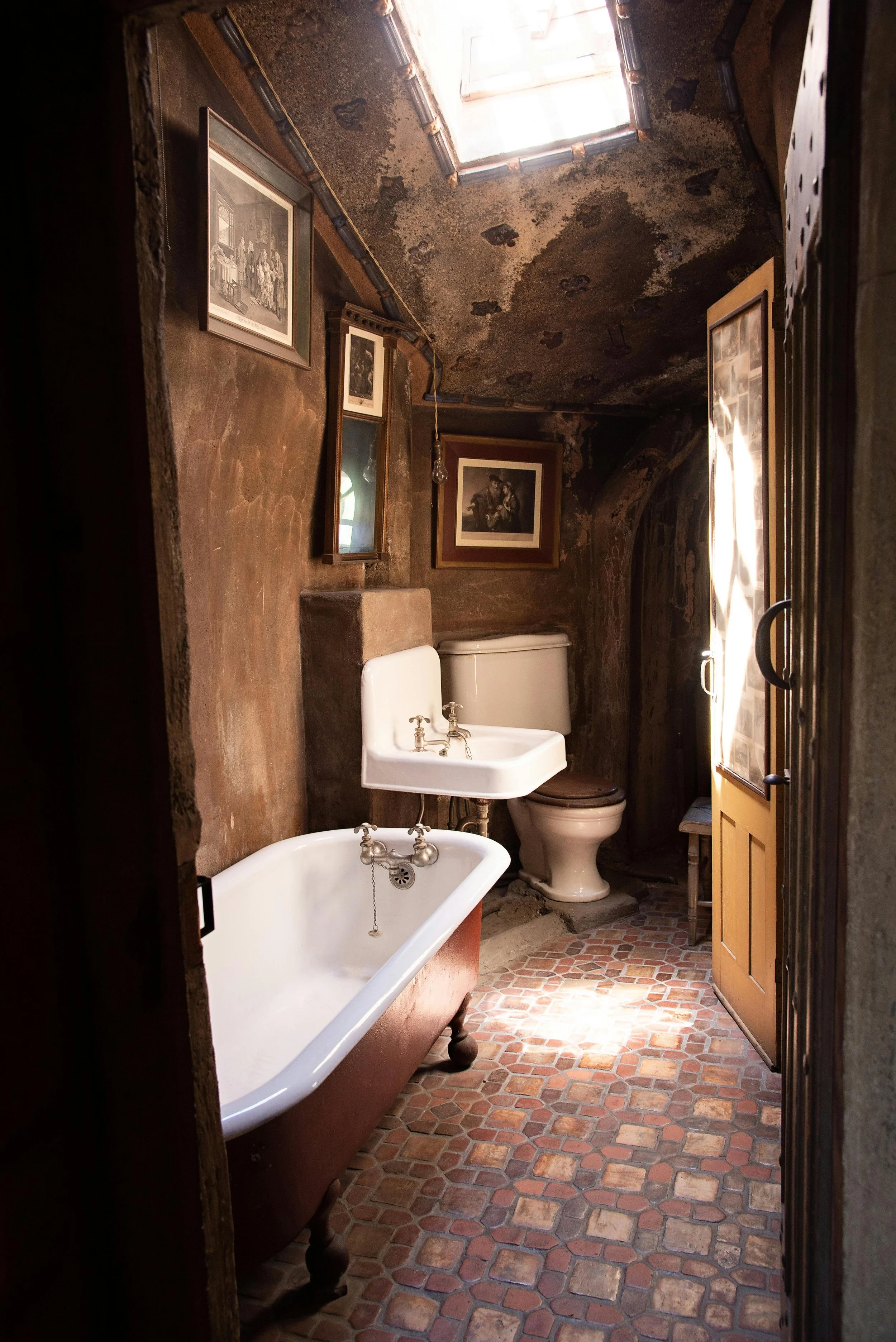 dark moody bathroom with rustic and industrial finishes with dark patterned tiled floor