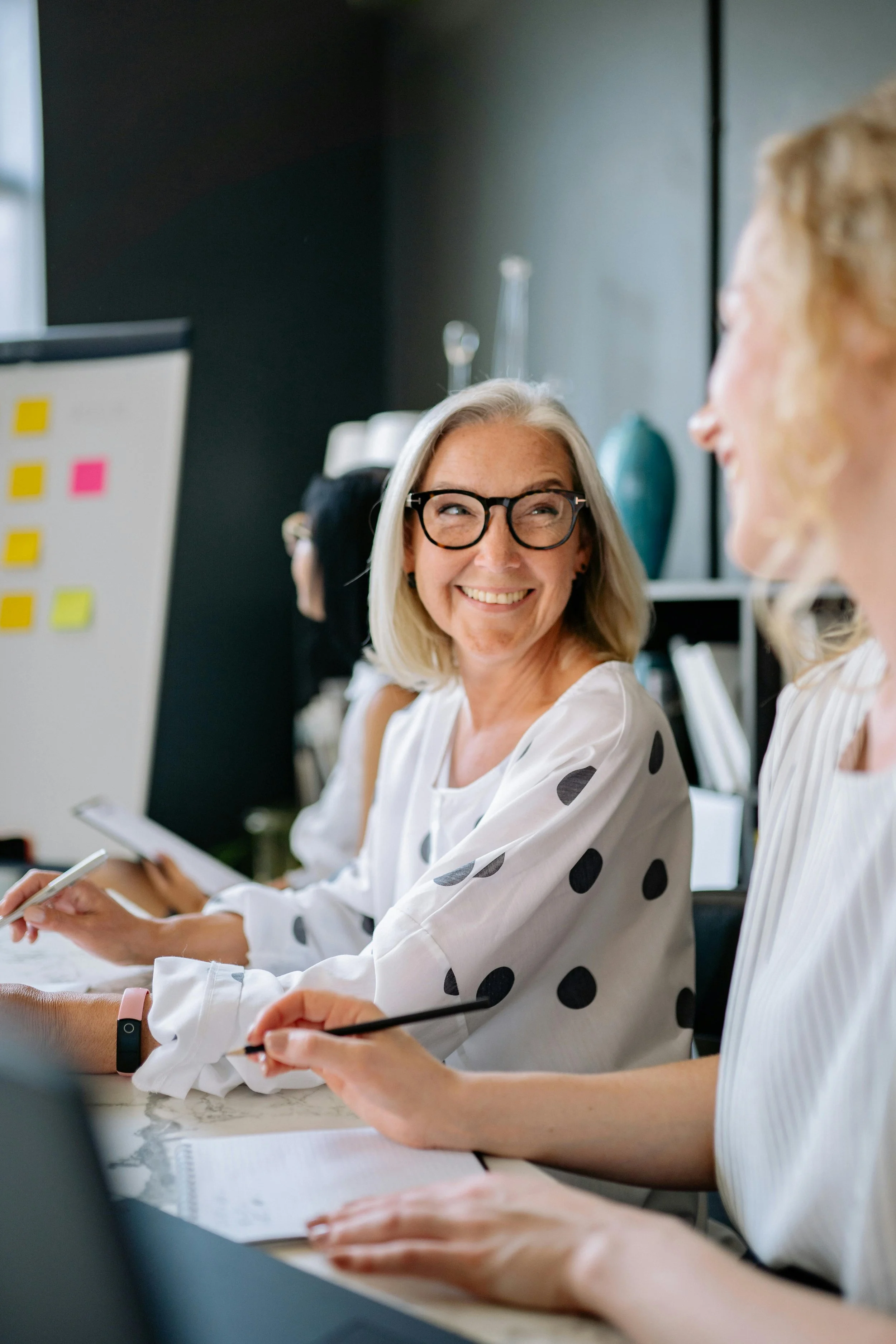 business owner sat with team talking and smiling