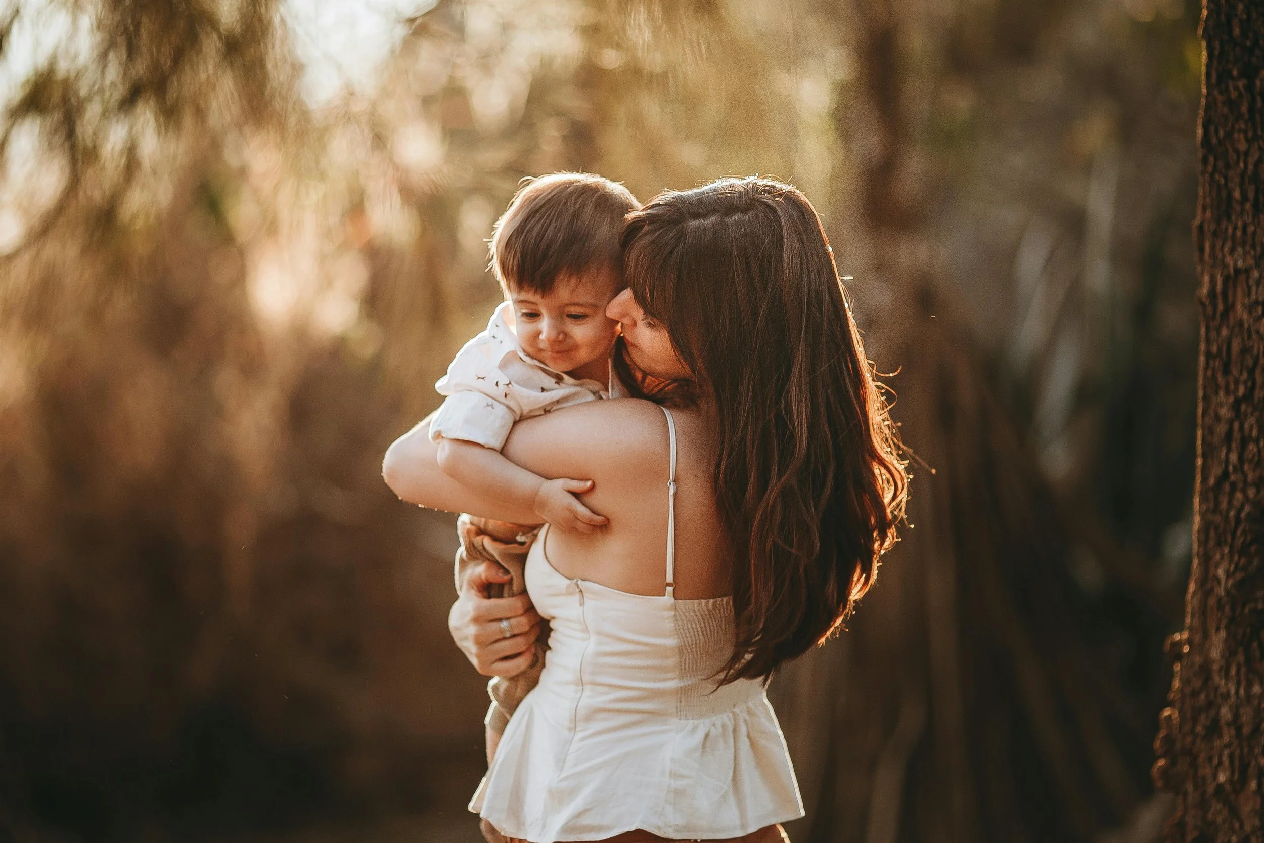 mother holding her baby in the woods