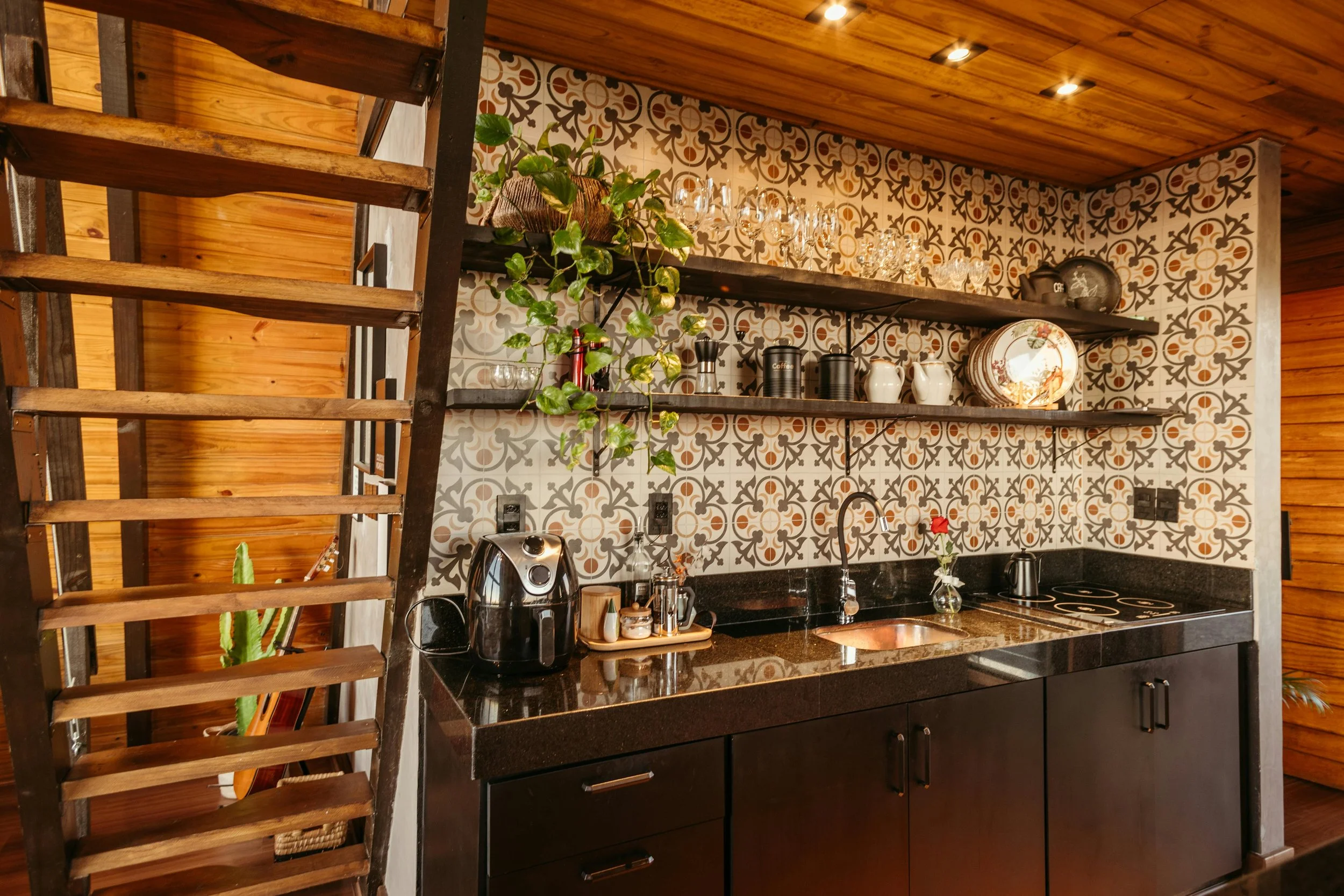 rustic holiday cabin with mosaic tiles and small kitchen with wooden details