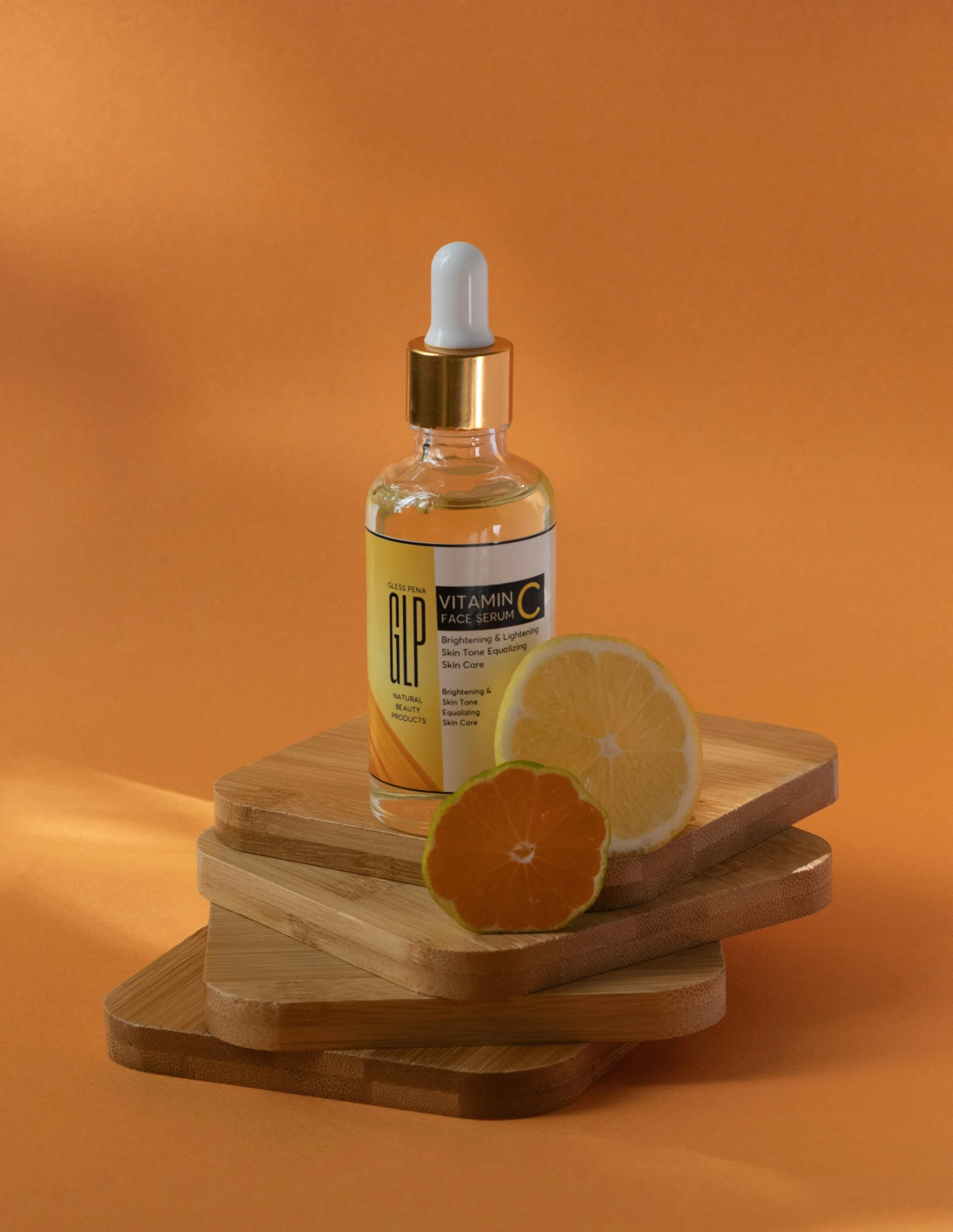 product against orange background with real fruit balanced on wooden blocks