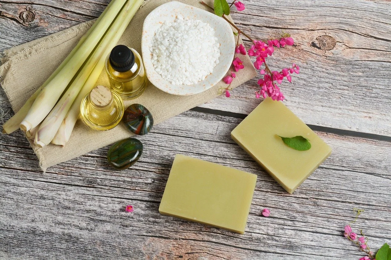 natural soaps with sea salts lemon grass and flowers on wooden board