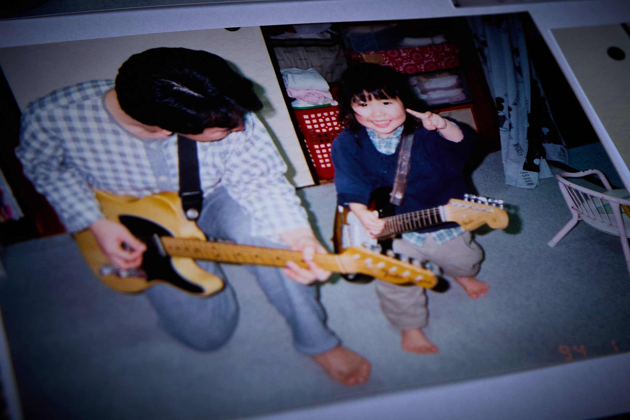 A father and child holding guitars