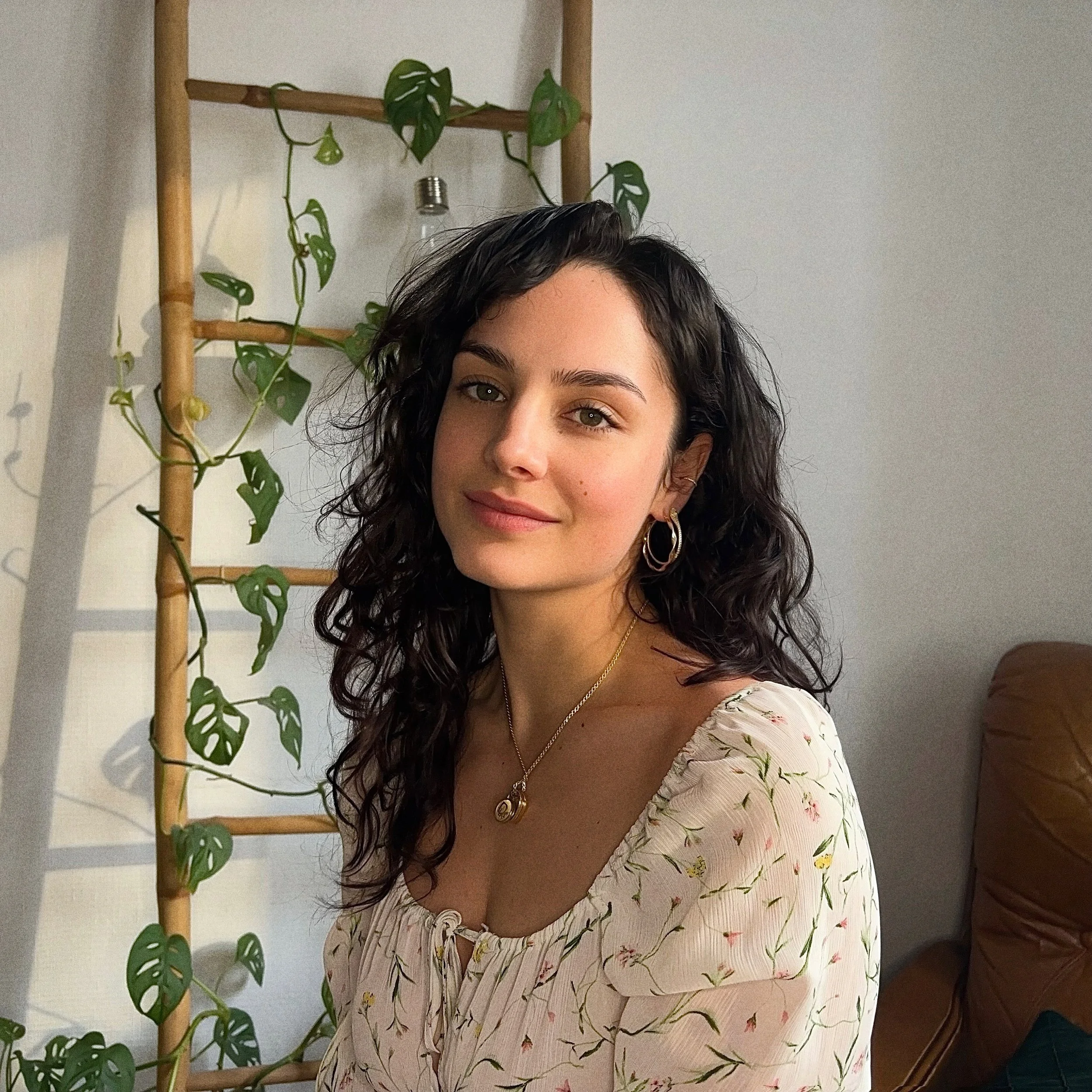 À mouchard entre le Jura et le Doubs, une doula aux cheveux noirs bouclés, portant une robe à fleurs. Elle pose avant un rendez-vous de préparation à l'accouchement et gestion de la douleur des contractions.
