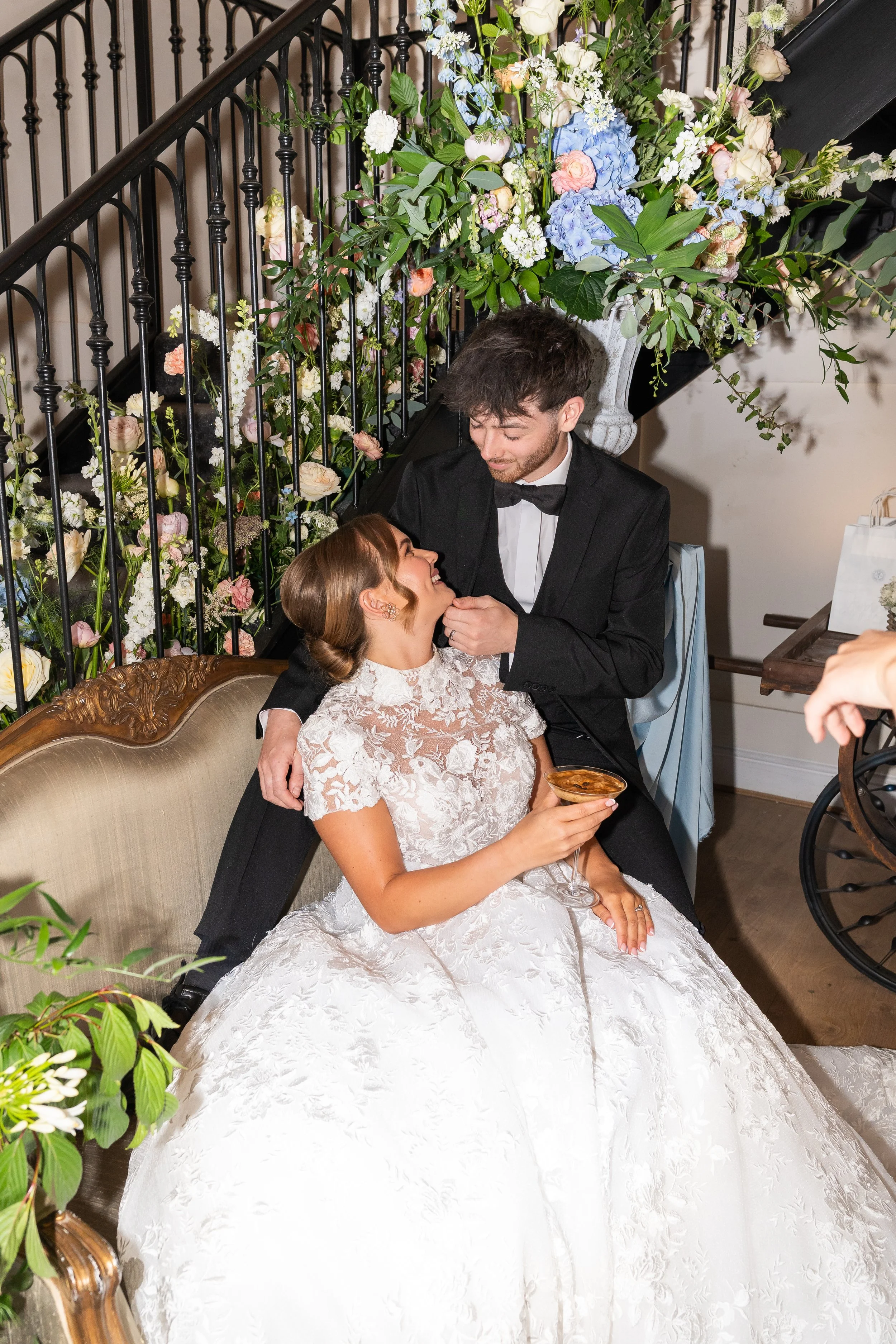 A bride and groom sharing an intimate moment at their wedding reception, surrounded by floral decorations and elegant furnishings. Styled shoot held at The Cheshire Venue planned by wedding planner Bootique Weddings and Events.