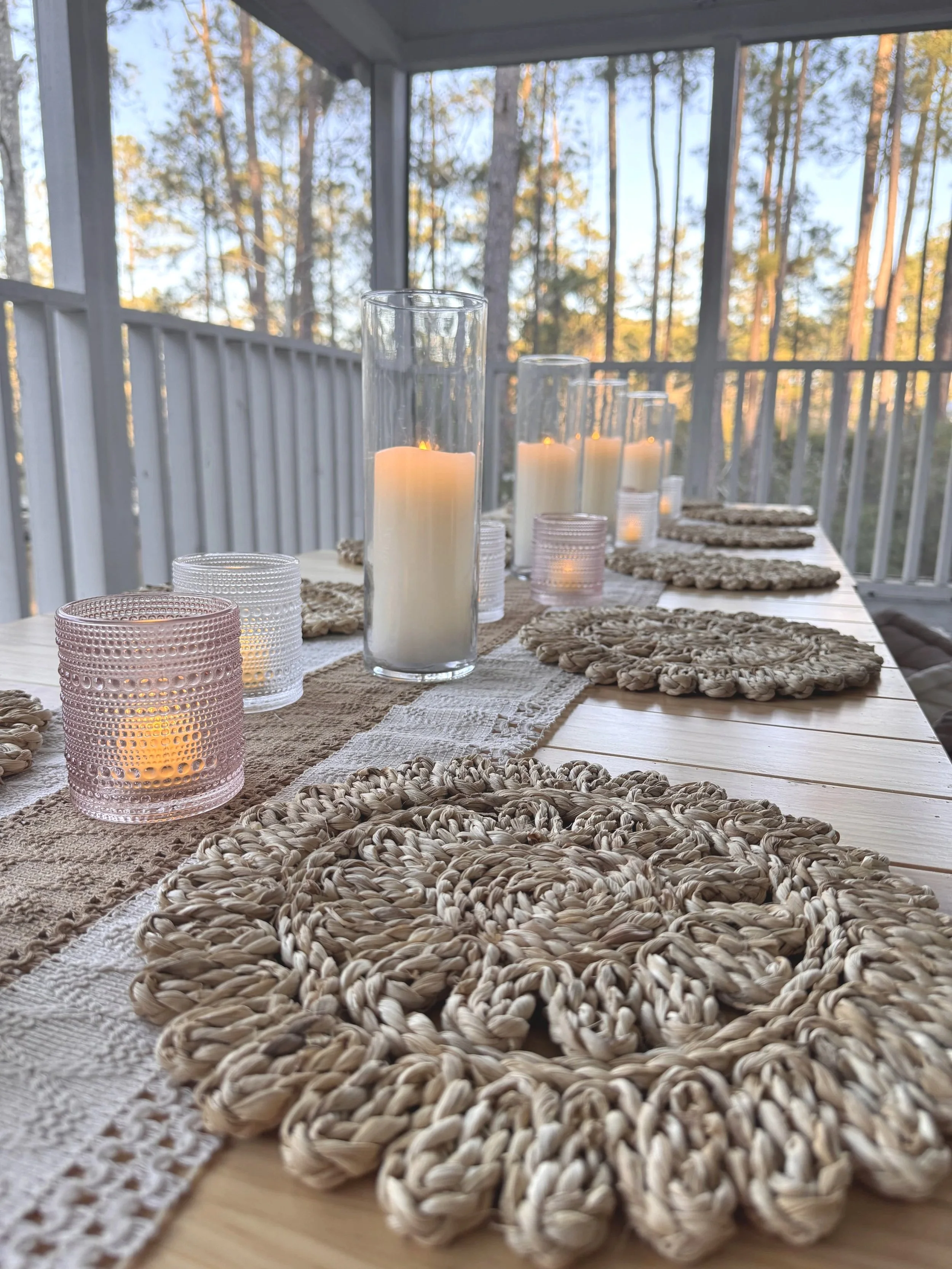 Elegant table setting with a floral centerpiece, glassware, and a folded napkin on a plate.