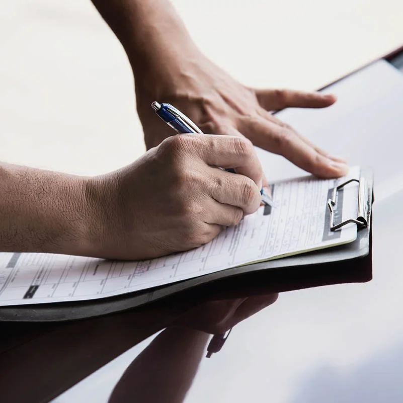 cropped-hands-person-holding-papers-car-hood.jpg