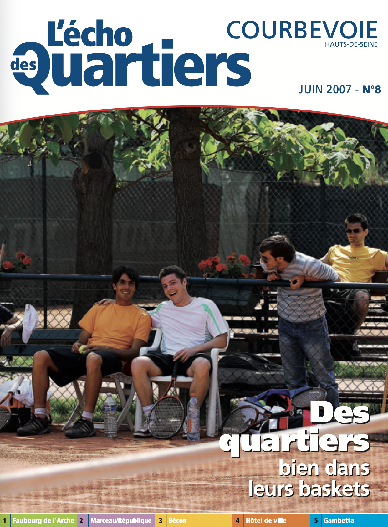 Photo de quatre amis jouant au tennis sur un terrain en extérieur, assis et debout près du filet, avec des raquettes et des bouteilles d'eau, sous un arbre, dans un parc urbain.