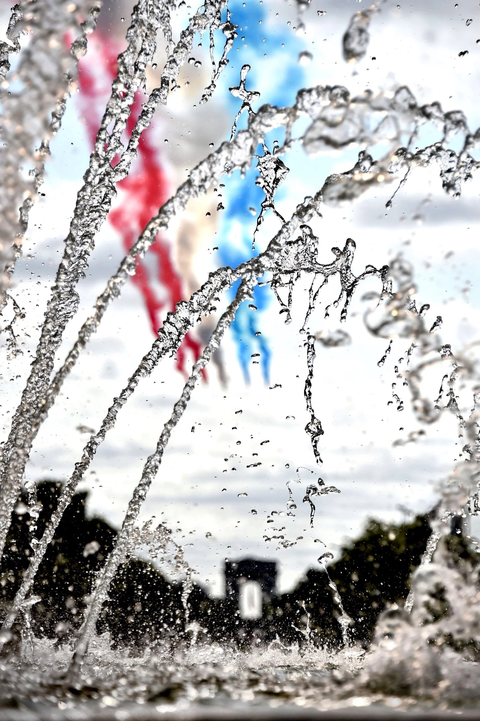 Gouttes d'eau sur une surface vitrée, avec un fond de ciel et de bâtiments, vue à travers une fenêtre après la pluie