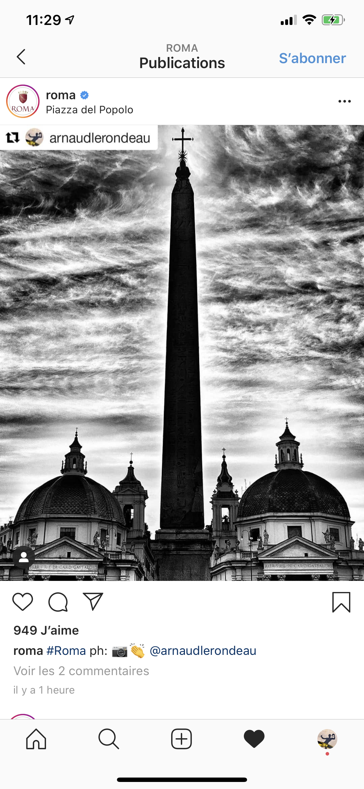 Une photo en noir et blanc de la Piazza del Popolo à Rome, montrant un obélisque au centre avec un ciel orageux en arrière-plan et deux dômes d'églises en bas.