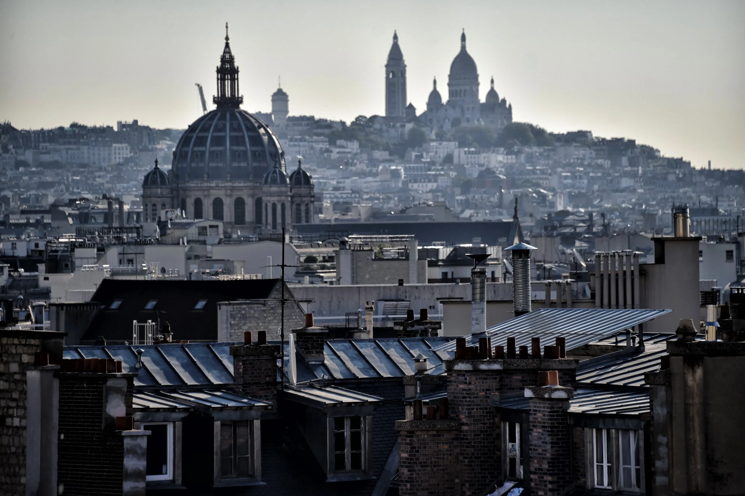 Vue de Paris avec la basilique du Sacré-Cœur visible au sommet de la colline Montmartre, en arrière-plan.