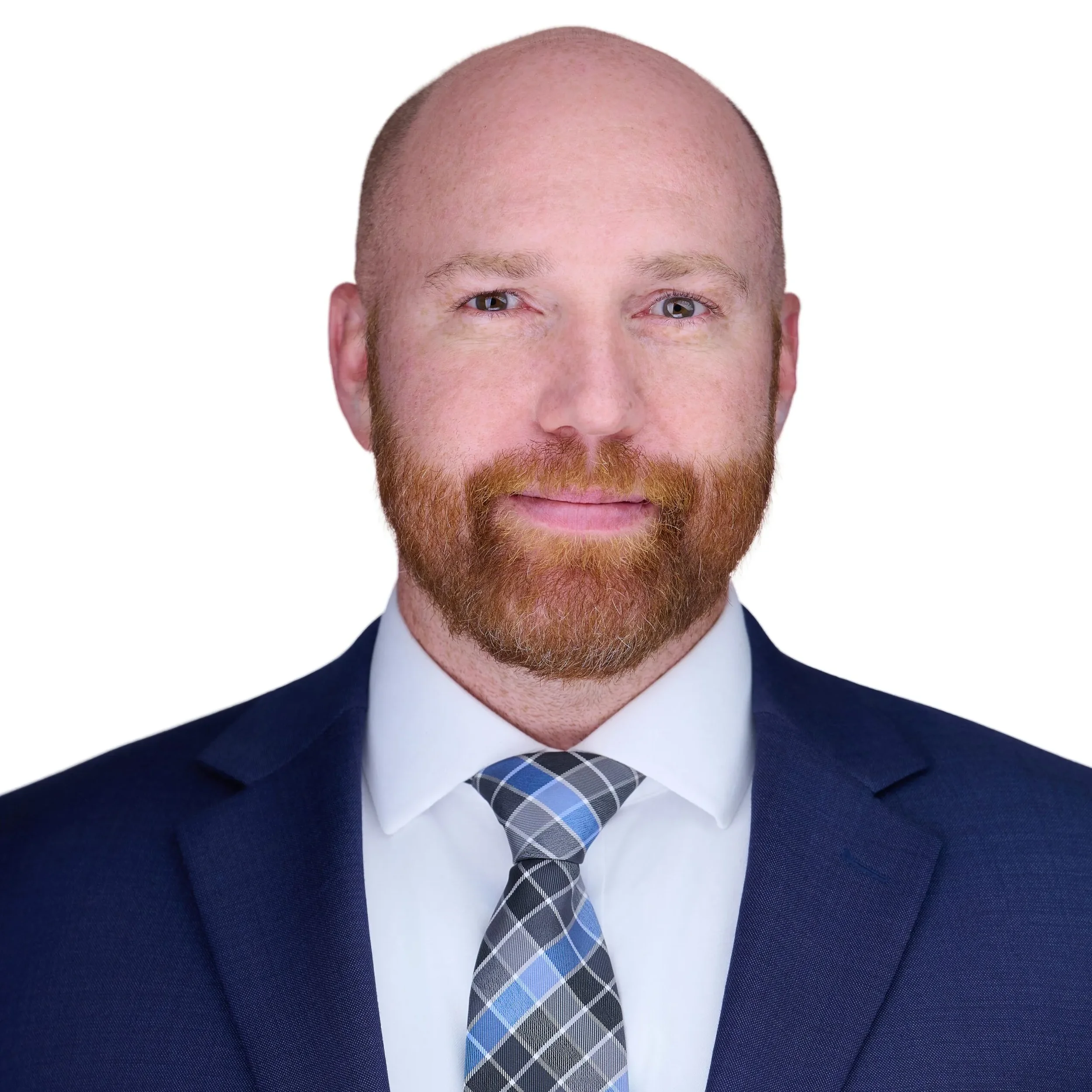 Close-up of a man with a bald head, red hair and beard, wearing a dark suit, white shirt, and a patterned tie, against a white background.