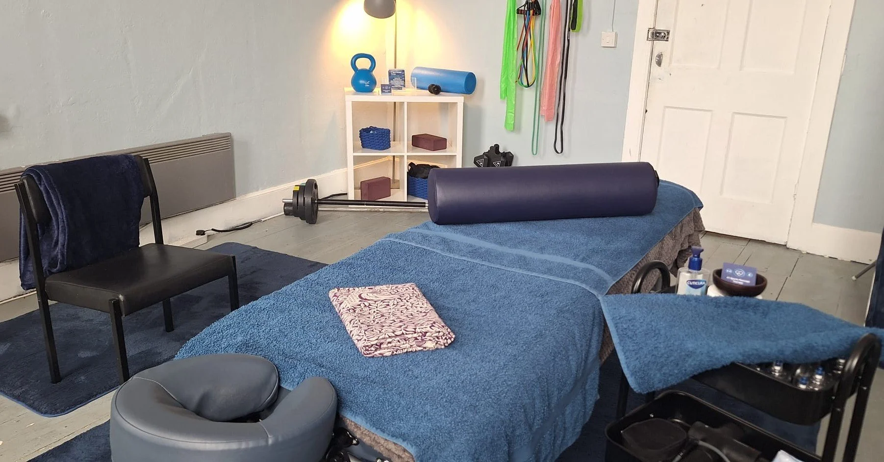 Massage room set up with blue towels and exercise equipment.