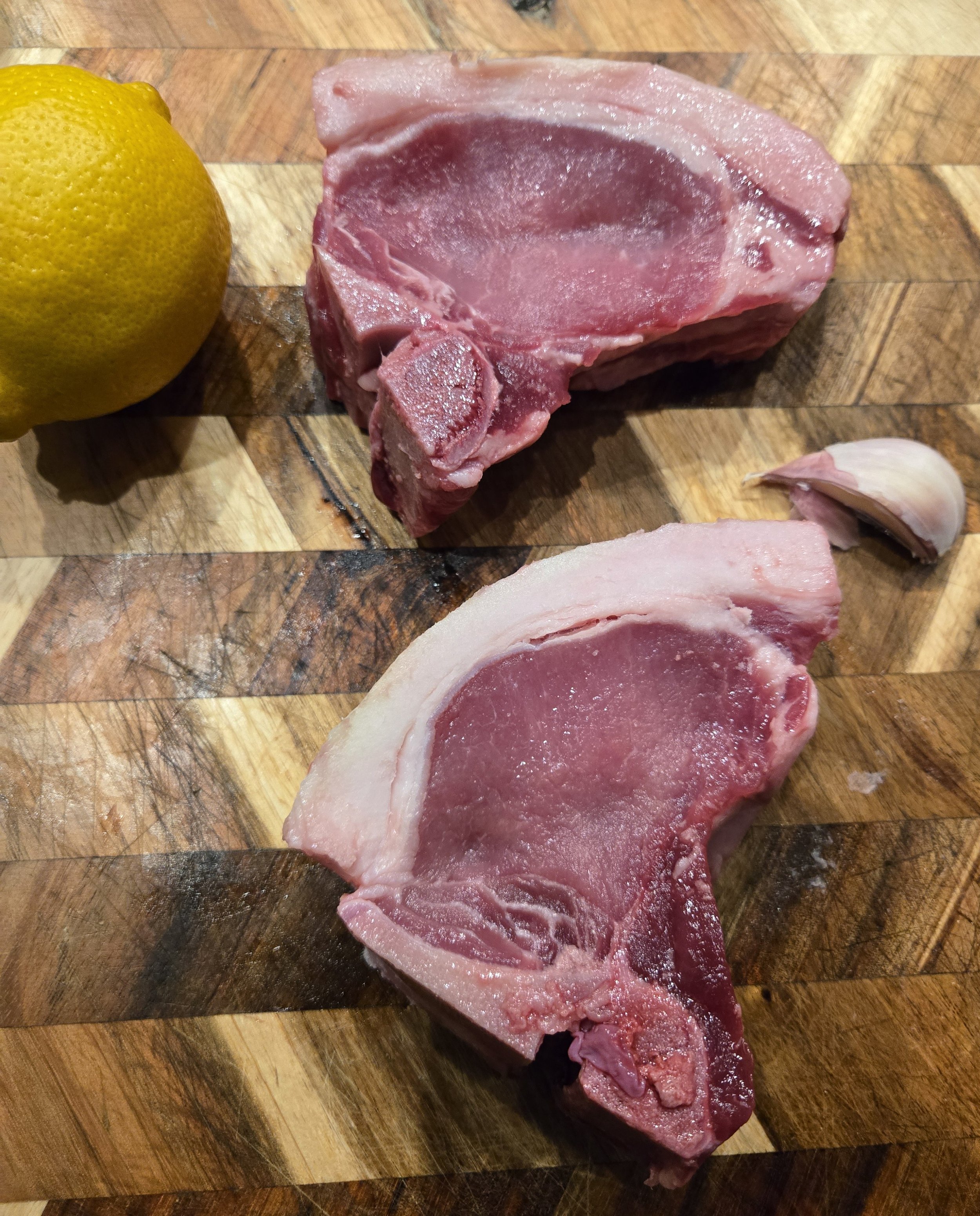 Bone-in Meishan pork chops on cutting board.