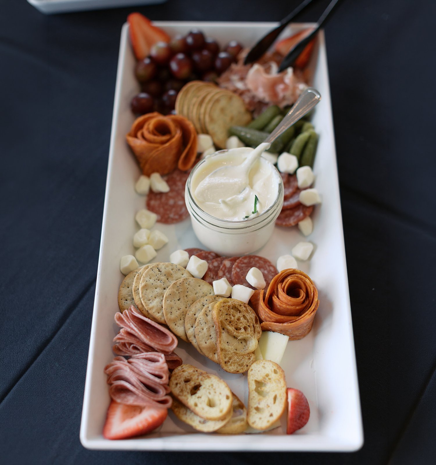Charcuterie board with assorted cheeses, meats, and spreads.