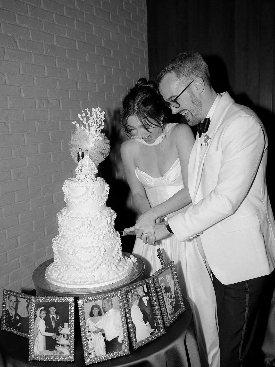 The most lovely couple cutting their vintage cake, with photos of their ancestors surrounding them to watch the history of the family heirloom cake topper continue. A gorgeous photograph 📸 by @fallonstovallphoto. Thank you @madisonbibb for choosing 