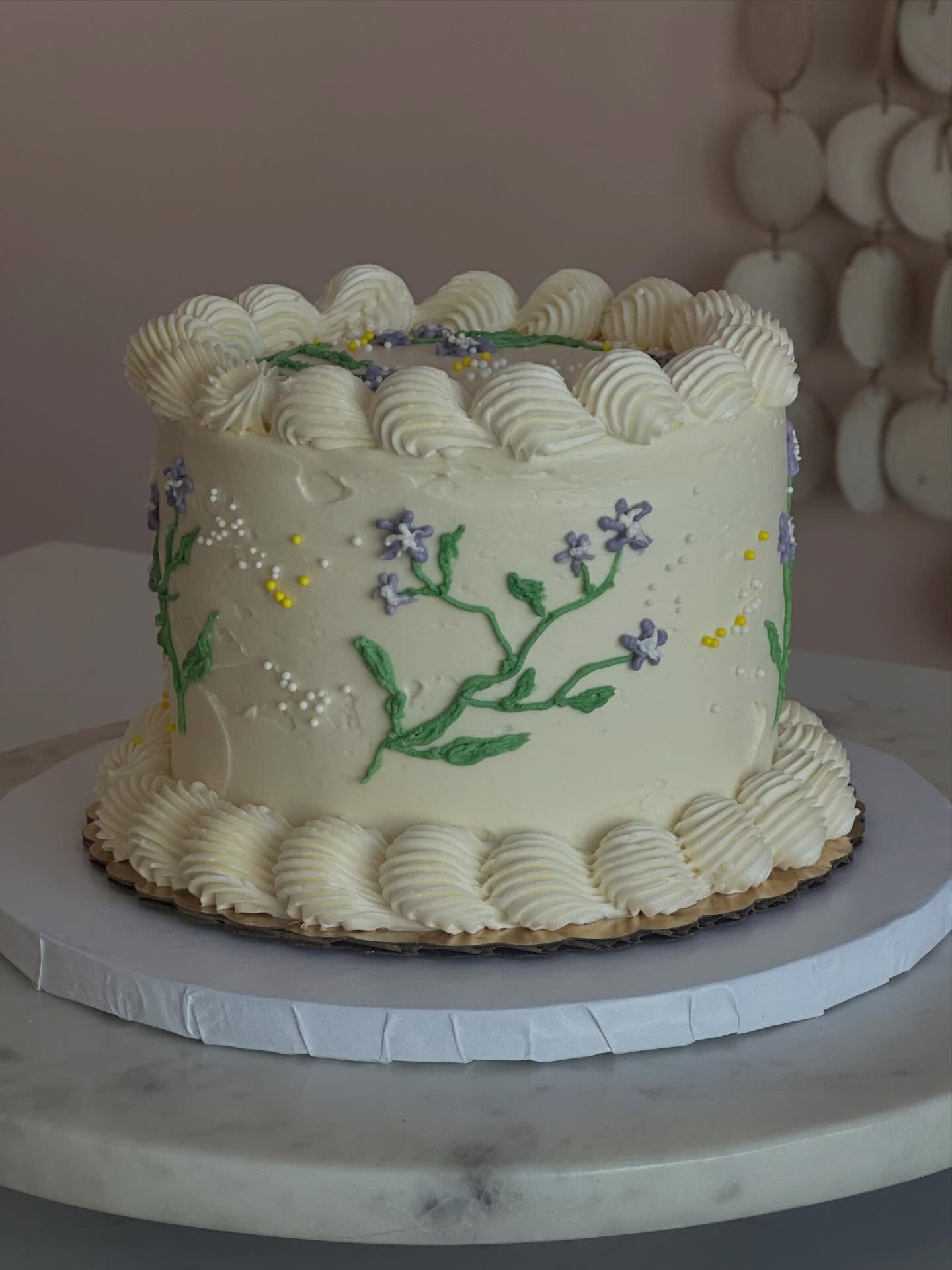 Sweet little purple flowers brightening up this darling 6&rdquo; cake. If we can&rsquo;t grow the spring flowers yet, dammit we will pipe them in buttercream! 💜🤍💛