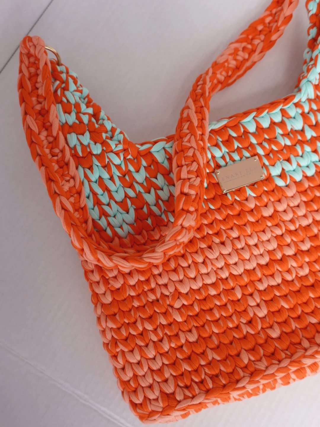 Hand-crocheted shoulder bag in orange, coral, and aqua with thick woven straps, measuring 32cm long, 6cm wide, and 33cm tall