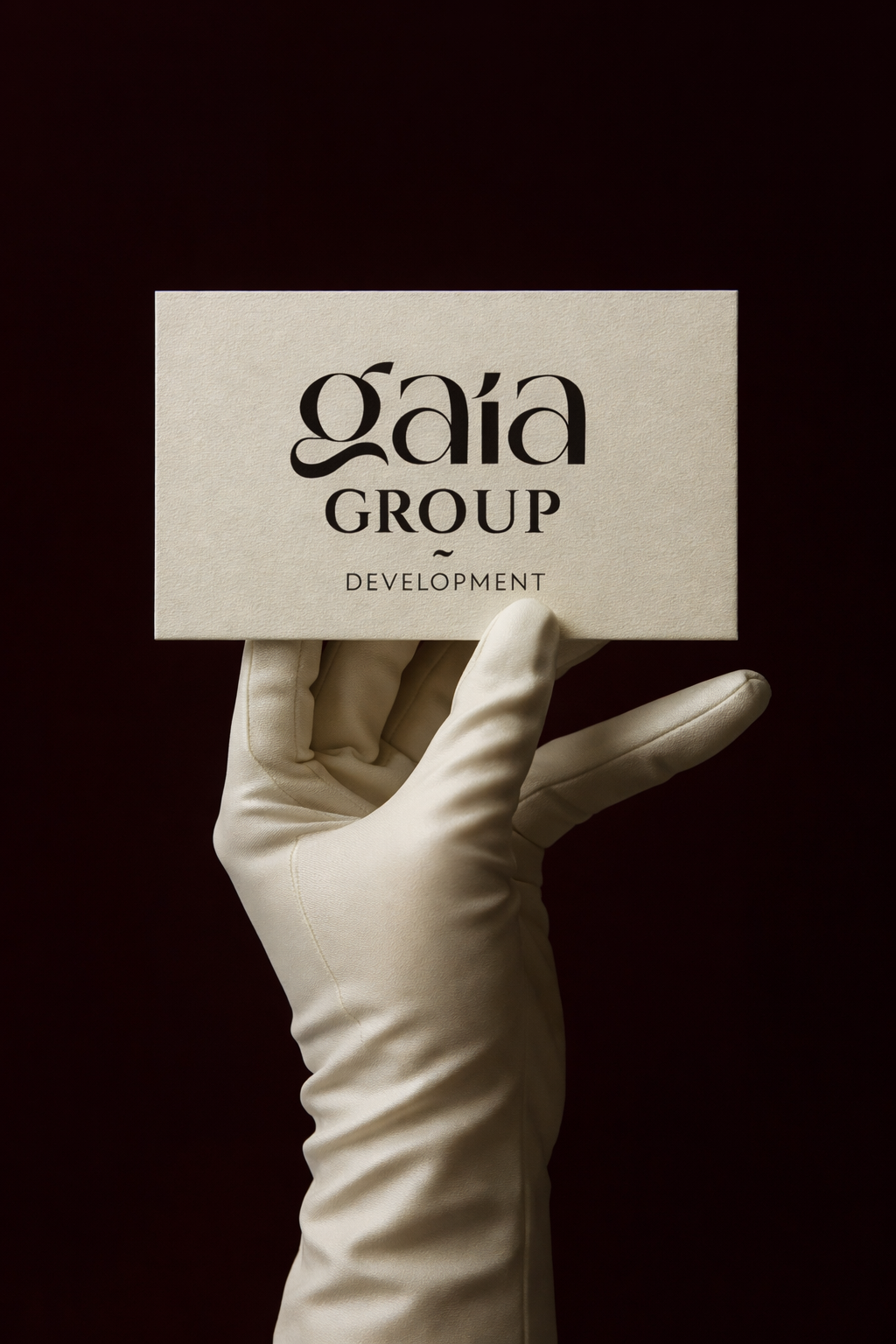 A hand in a white glove holding a card with the text 'gáðG GROUP DEVELOPMENT' against a dark background.