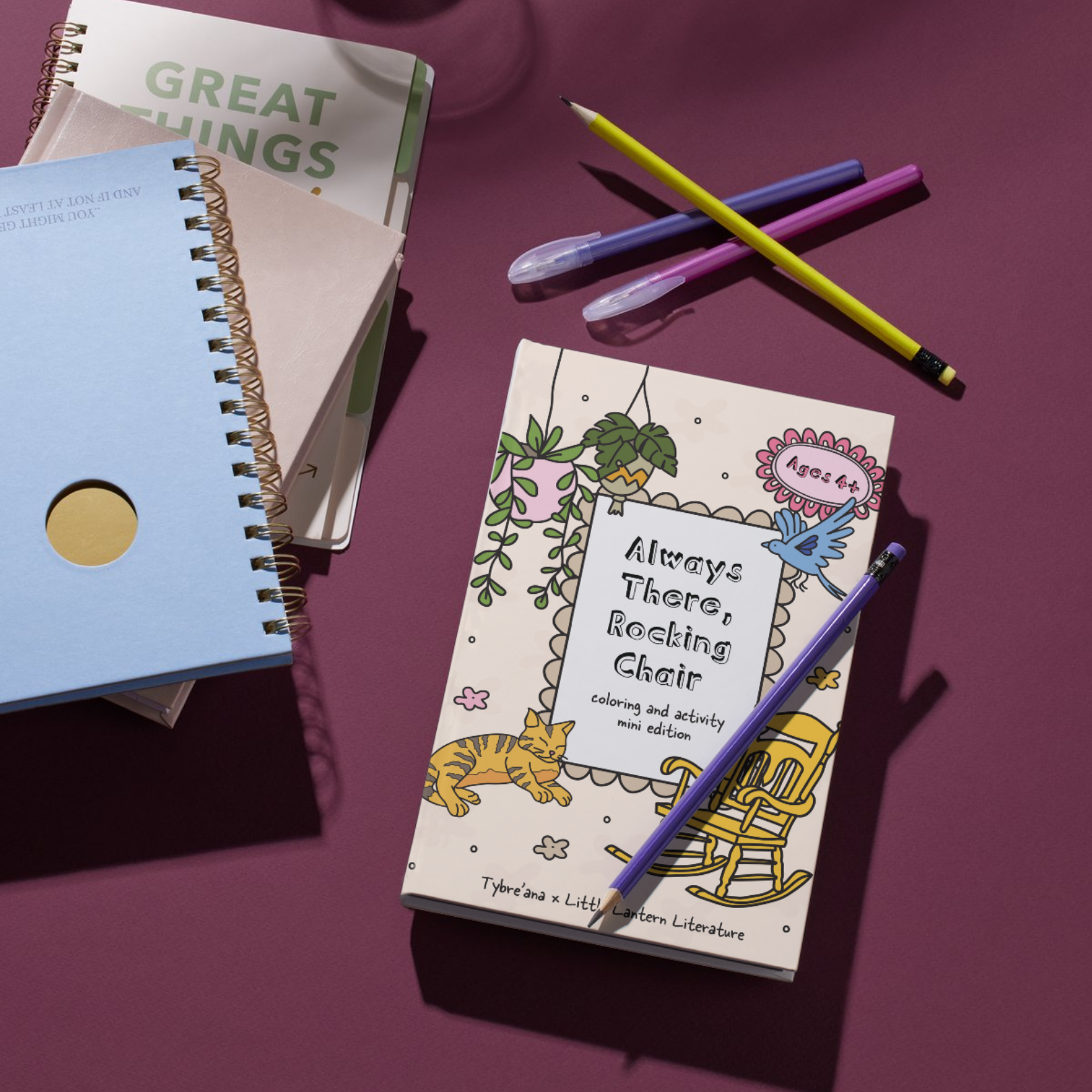 Coloring book titled "Always There, Rocking Chair" on a purple surface with three pens and notebooks nearby.