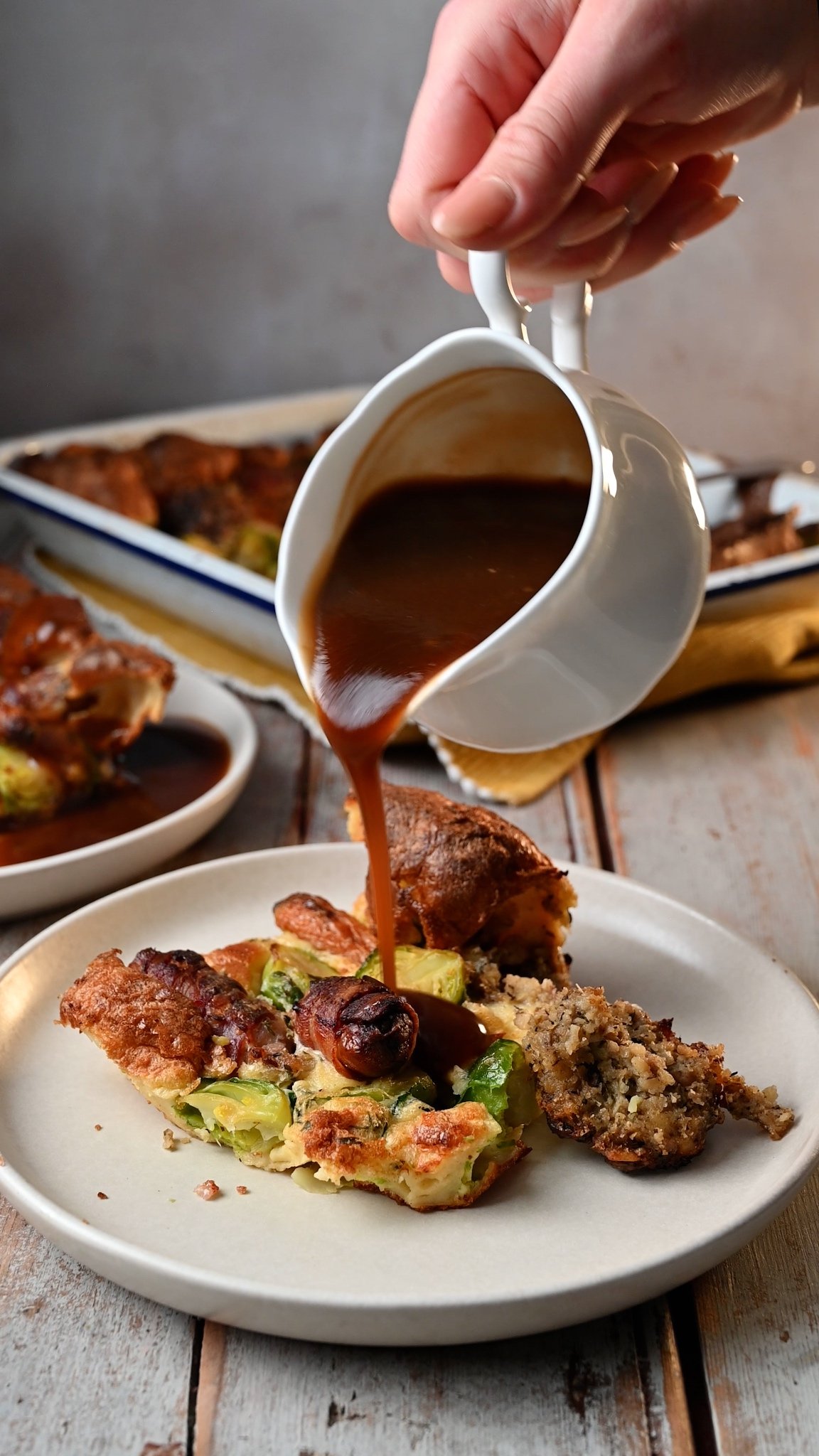 Slice of leftover Christmas toad in the hole being served with gravy