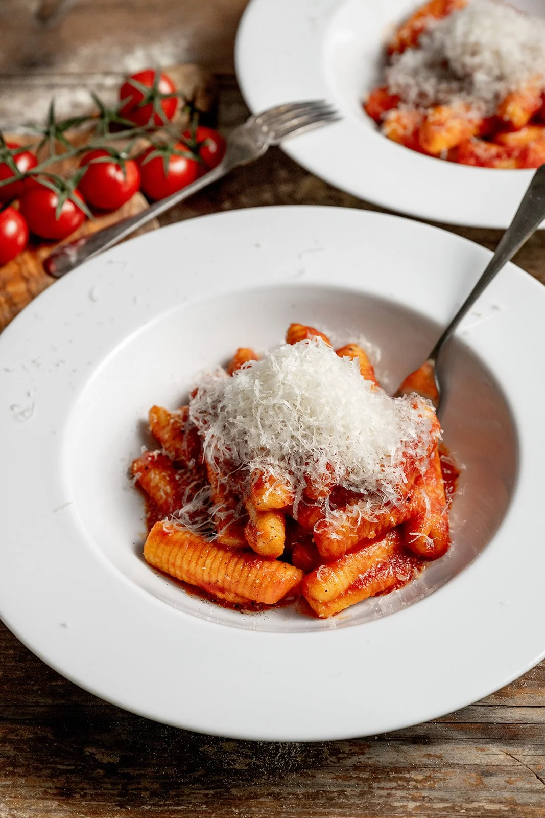 Plate of cavatelli rigati lunghi with tomato sauce and grated parmesan
