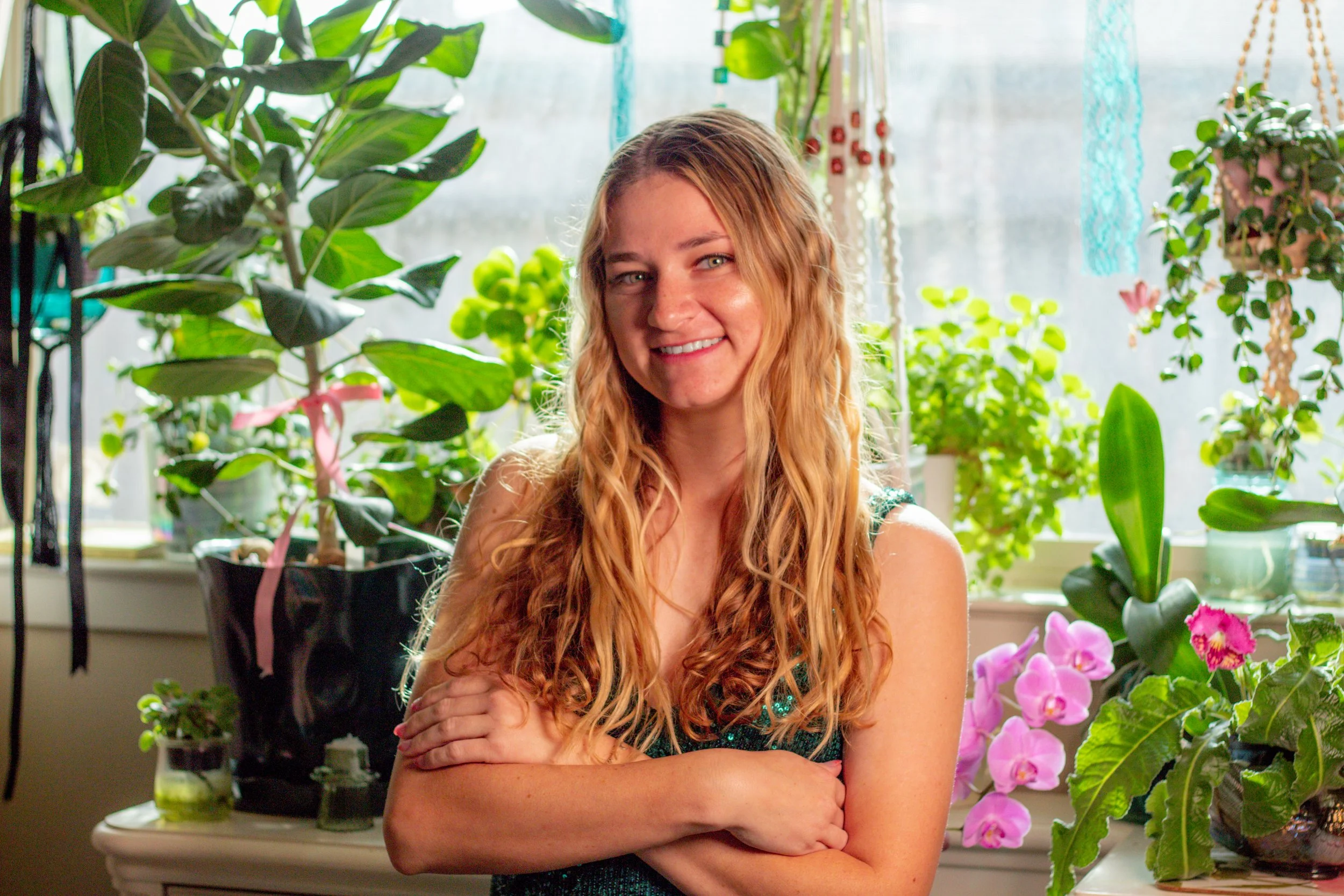 Headshot of Rachel Reynolds, founder of Bird’s Eye Visual Merchandising, photographed among lush plants in a garden center setting.