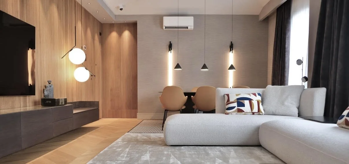 Salón con sofá blanco y detalles de color en piso reformado en Barrio El Retiro