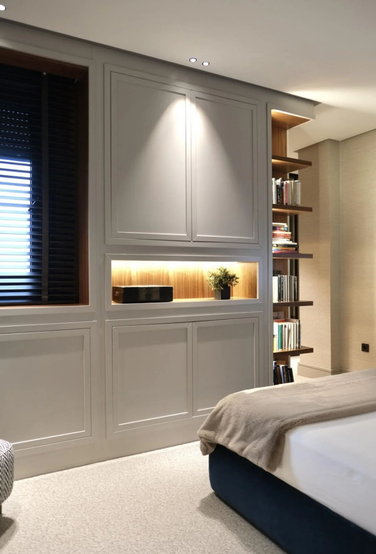 Dormitorio con pared empotrada gris y estanterías de madera en piso reformado en Barrio El Retiro