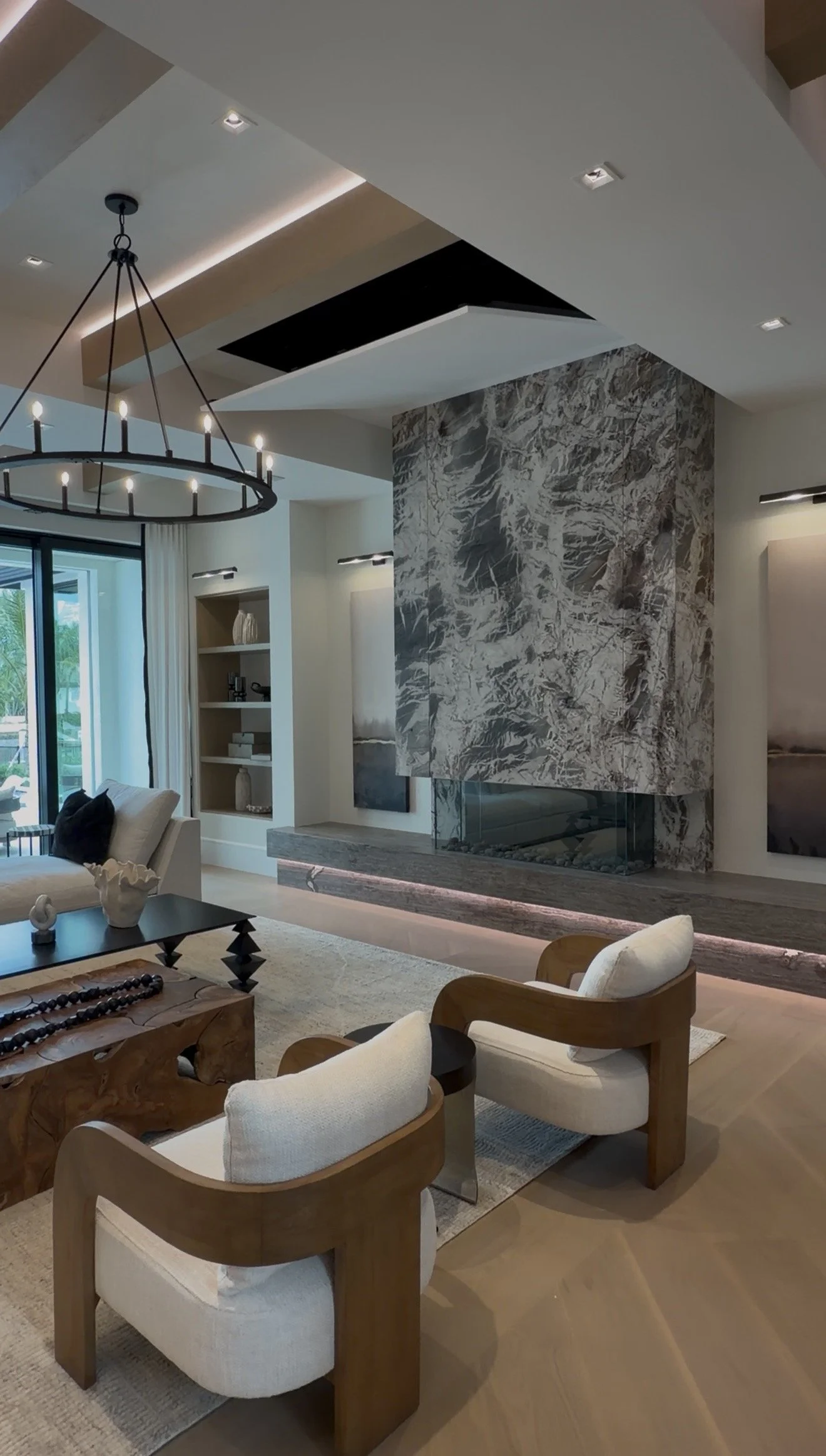  Great room at 1340 Spyglass showing oak ceiling beams, concealed lighting, and the television recessed above the stone fireplace. 