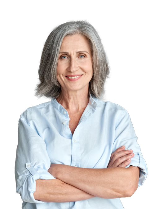 Older woman with gray hair wearing a light blue shirt, smiling with arms crossed.