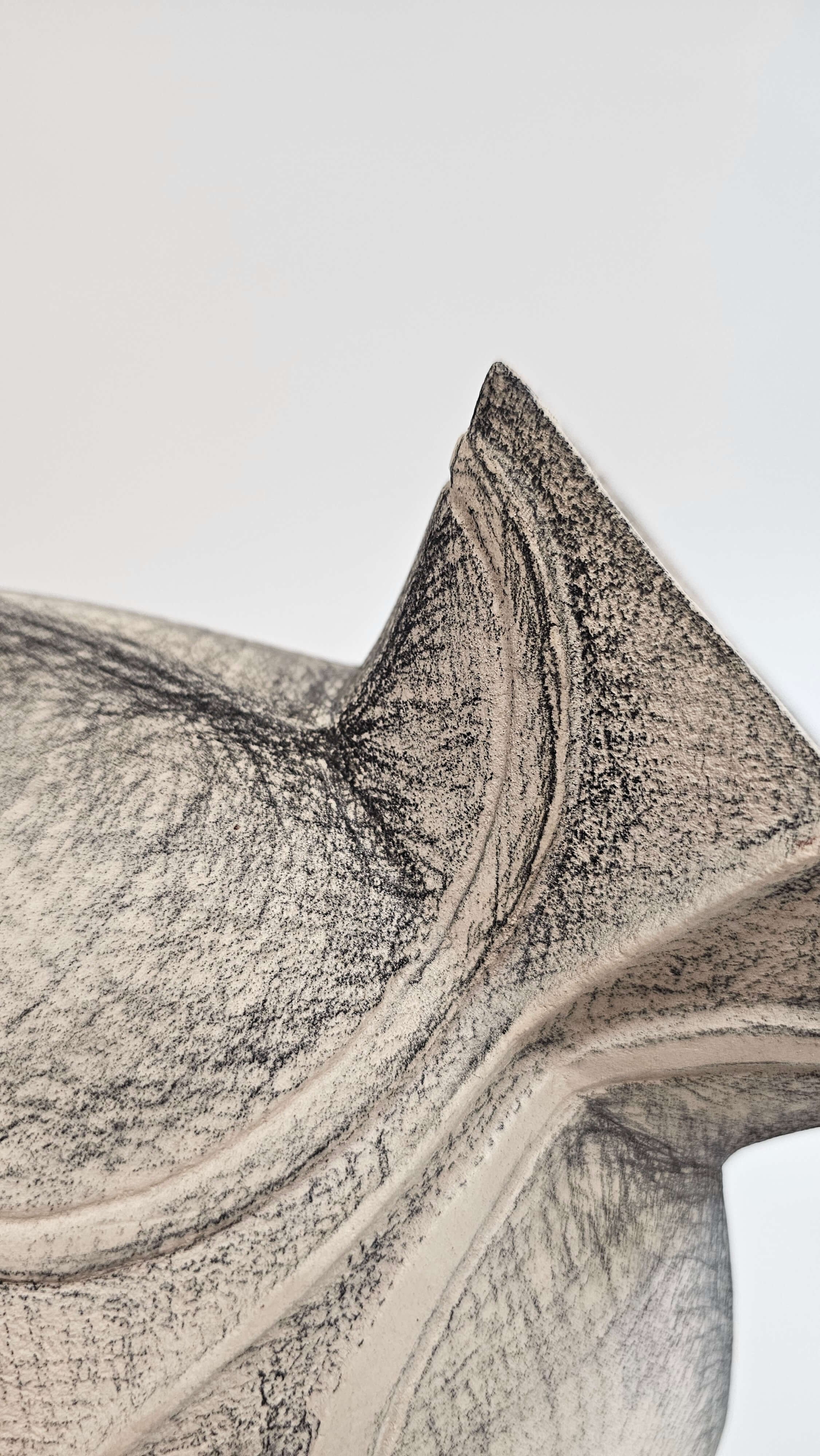 Close-up of a textured, abstract sculpture with smooth, curved surfaces and intricate grain patterns.