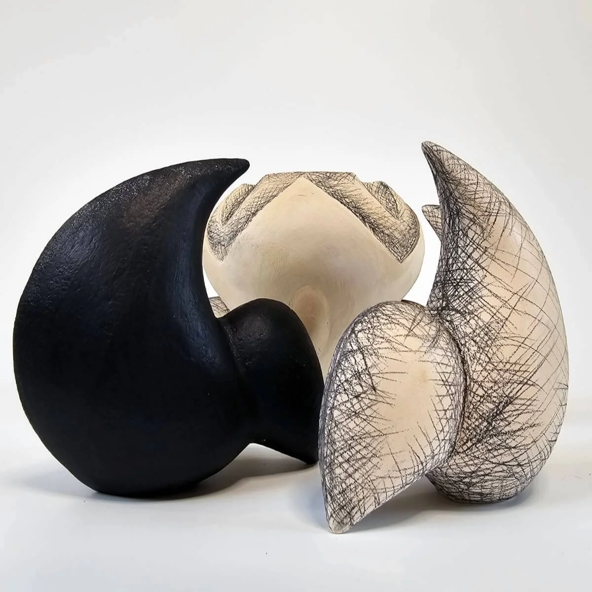 Mirsini Roumelioti. Mirsini Ceramics. Together. Three abstract ceramic sculptures with curved shapes and mixed textures, set against a plain white background.