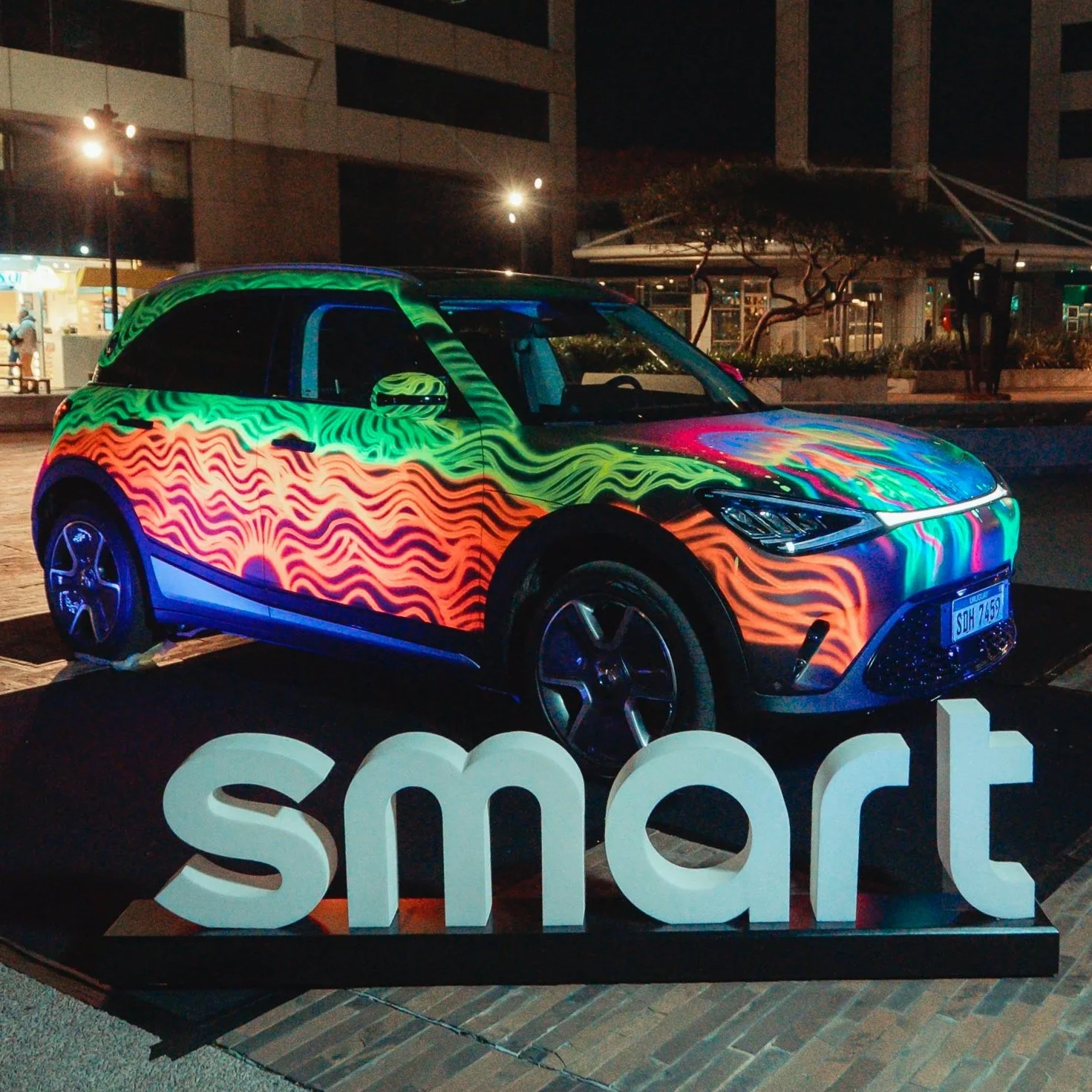 Auto smart intervenido en vivo con aerosoles fluorescentes por la artista Paz Verdias