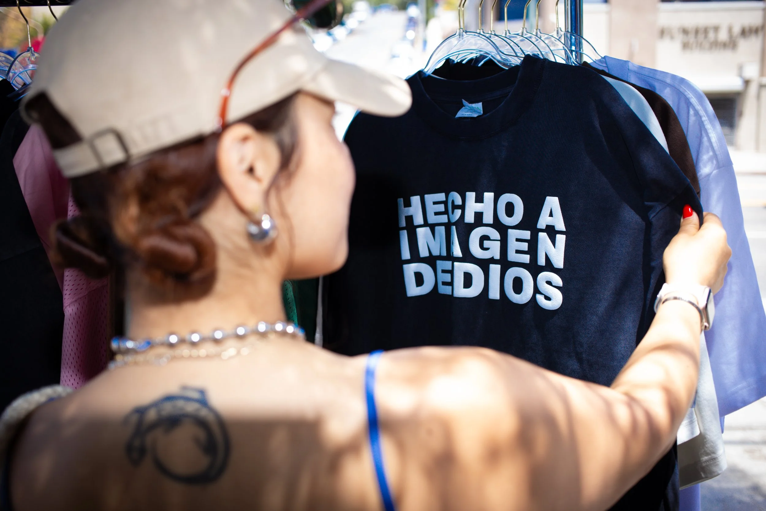 KingsHope vendor rack showing Hecho A Imagen De Dios tee at outdoor pop-up