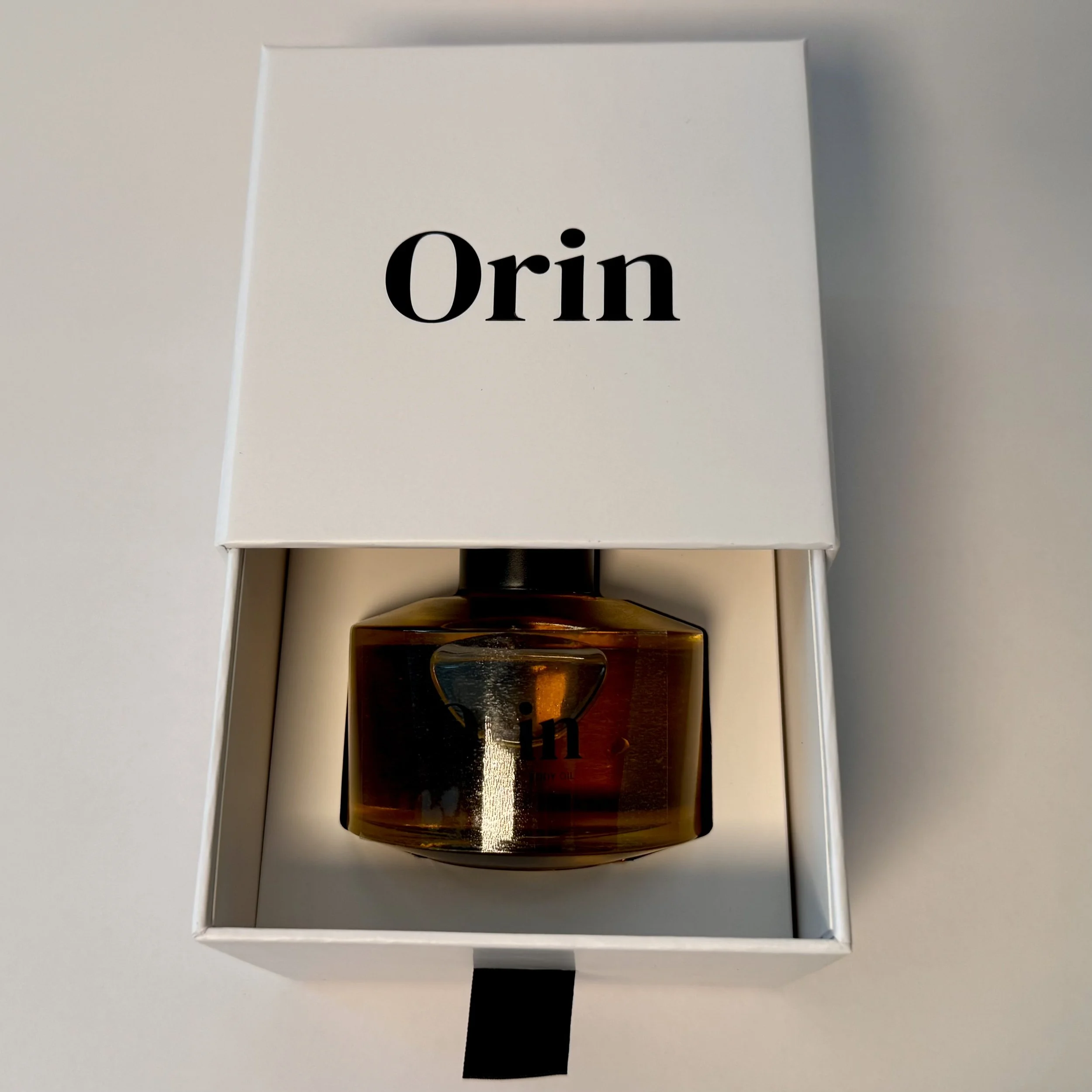 100ml Orin Bulgarian Rose Body Oil nestled in an open white luxury drawer box. This premium presentation showcases our botanical oil, formulated for deep lipid barrier nourishment and renewal.
