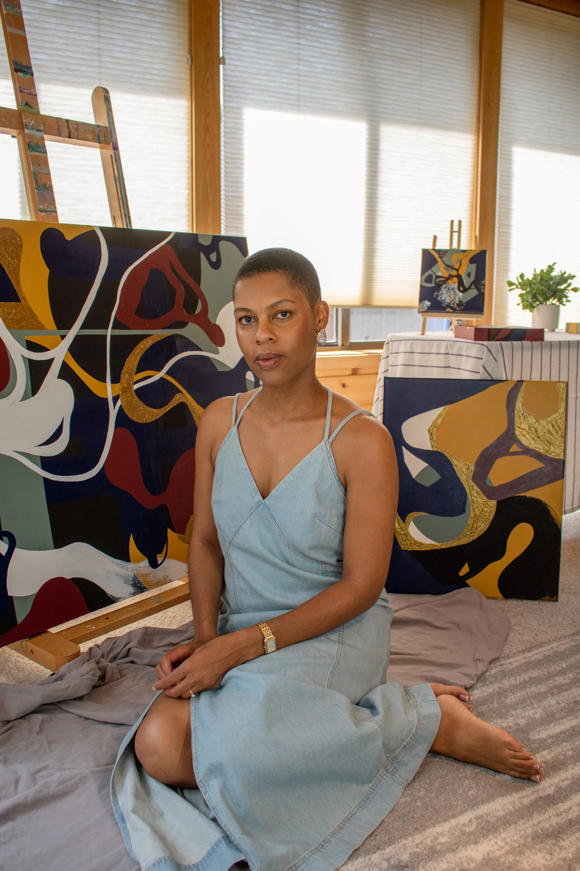 Portrait of Minnesota abstract artist Nailah Ali with original abstract paintings from the Moments in Grief collection.