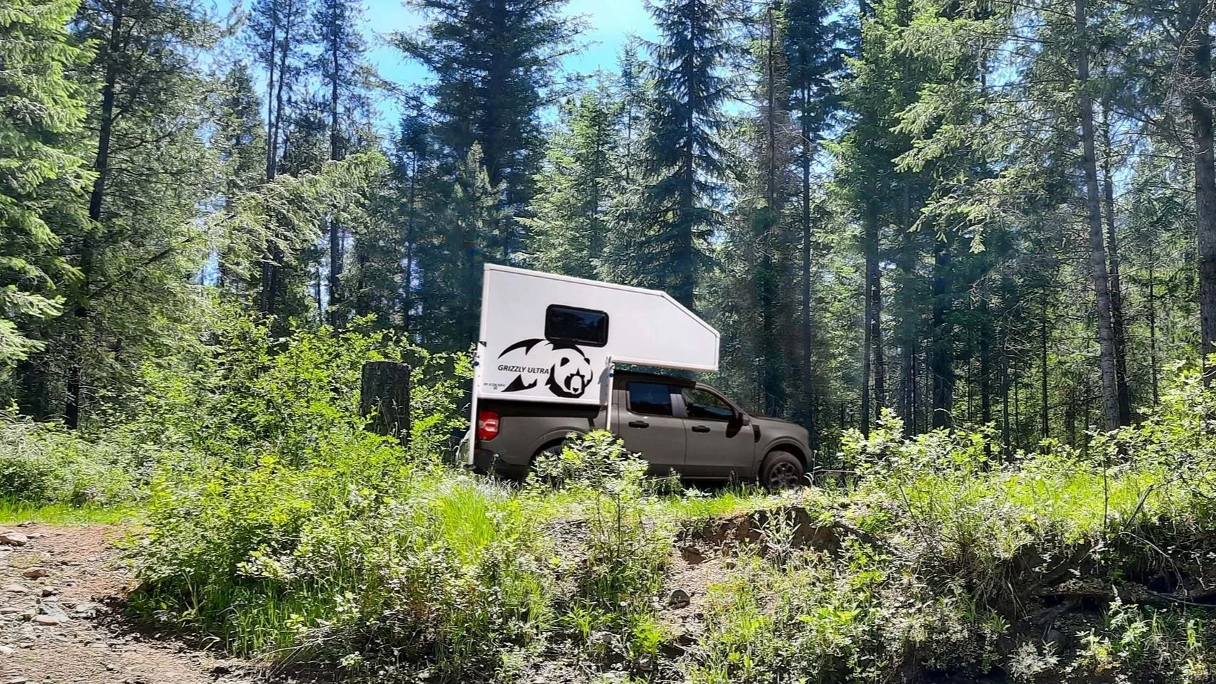 Image of Grizzly Adventure Trailer in the forest.
