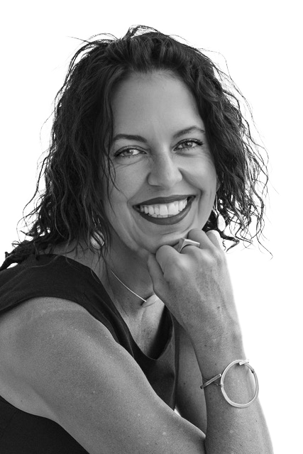 A headshot of Molli Milner in black and white. She is smiling wide.